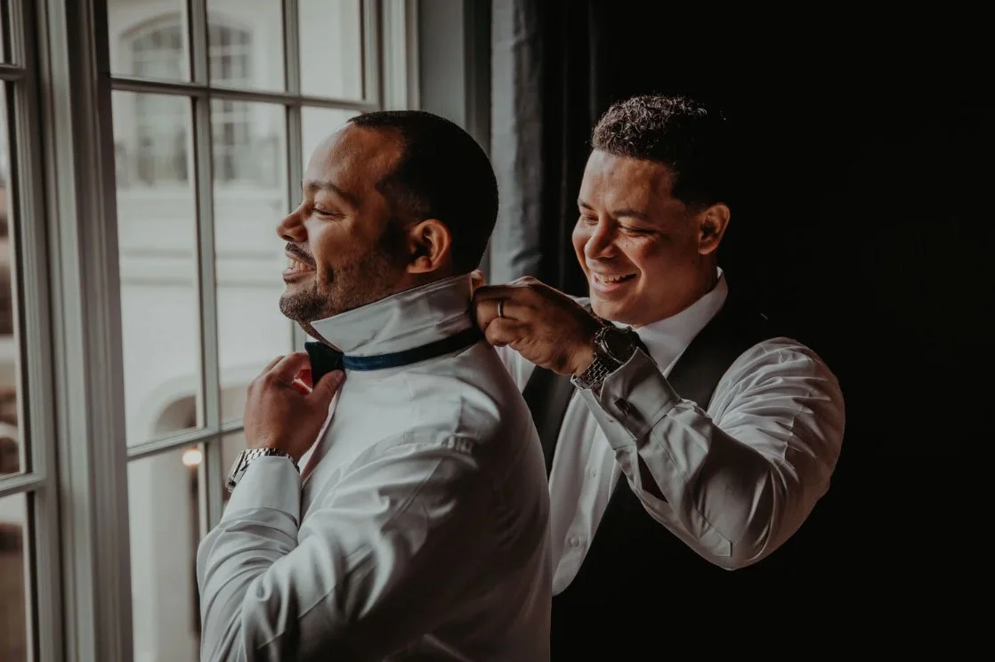 Groom is getting his tie put on with the help of his groomsman at Park Chateau NJ Wedding Venue
