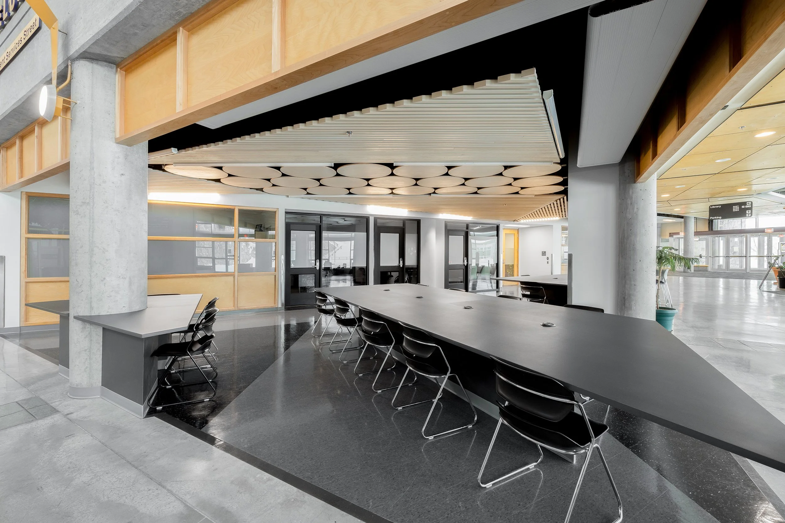 Recruitment, admissions and finincal assistance advising in background.  Custom tables and ceiling millwork in foreground.   