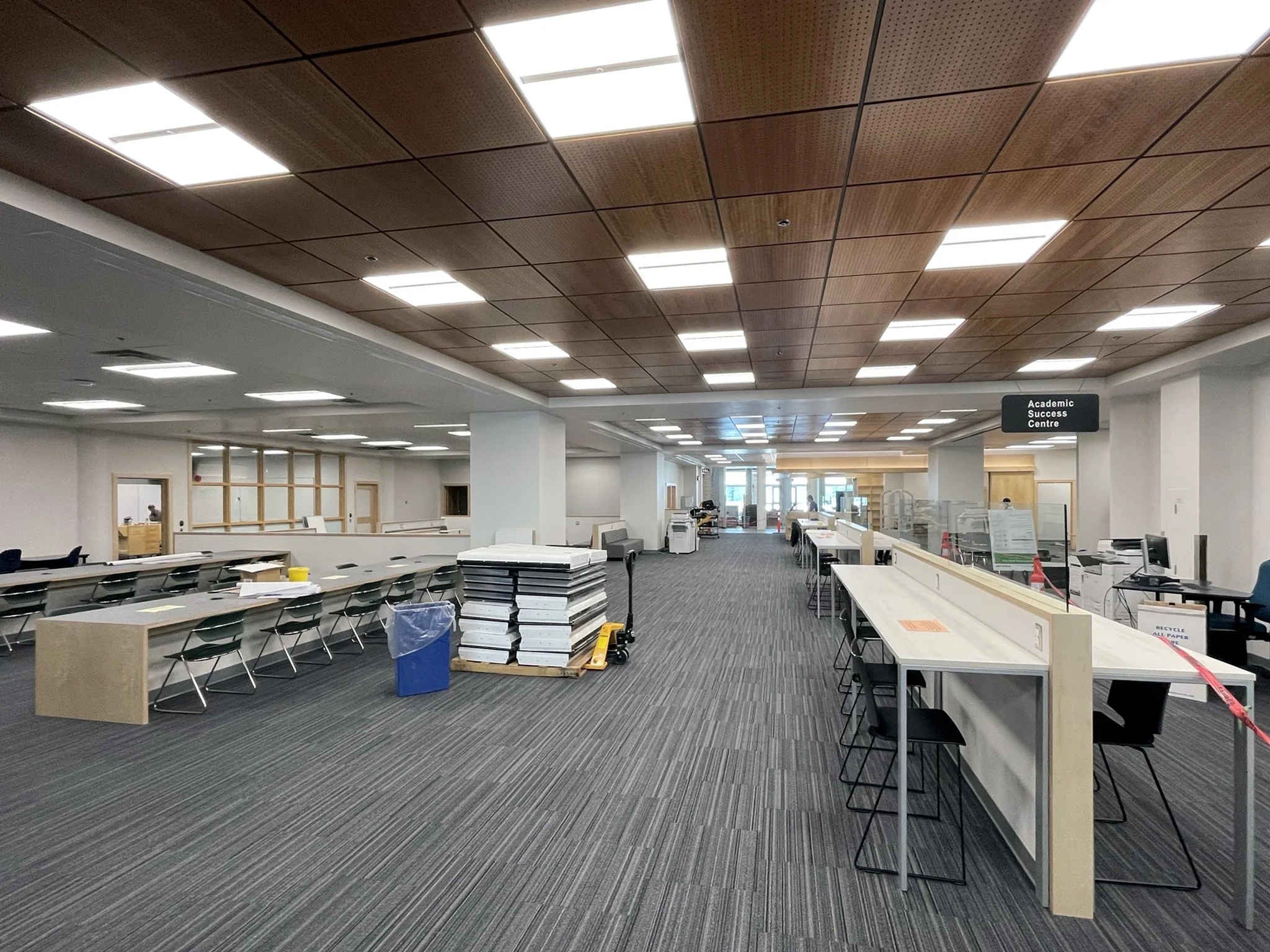  Interior street providing sightlines, daylighting and circulation.  High top tables with glazed covid screens.   