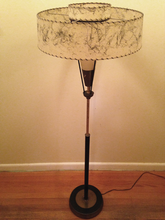 Vintage Mid-Century Modern Brass & Fiberglass Floor Lamp Black & Brass Floor Lamp with natural patina finish. 2-Tier Fiberglass shade with whip-stitch edging (mostly intact except for 2-stitches). Cone-shaped fiberglass inner bulb shade. Brass base has a few minor dings. Original electrical wiring - lamp works with a bit of play—needs adjustment. 19"di" shade. 58"high. 10.5"di base. $250