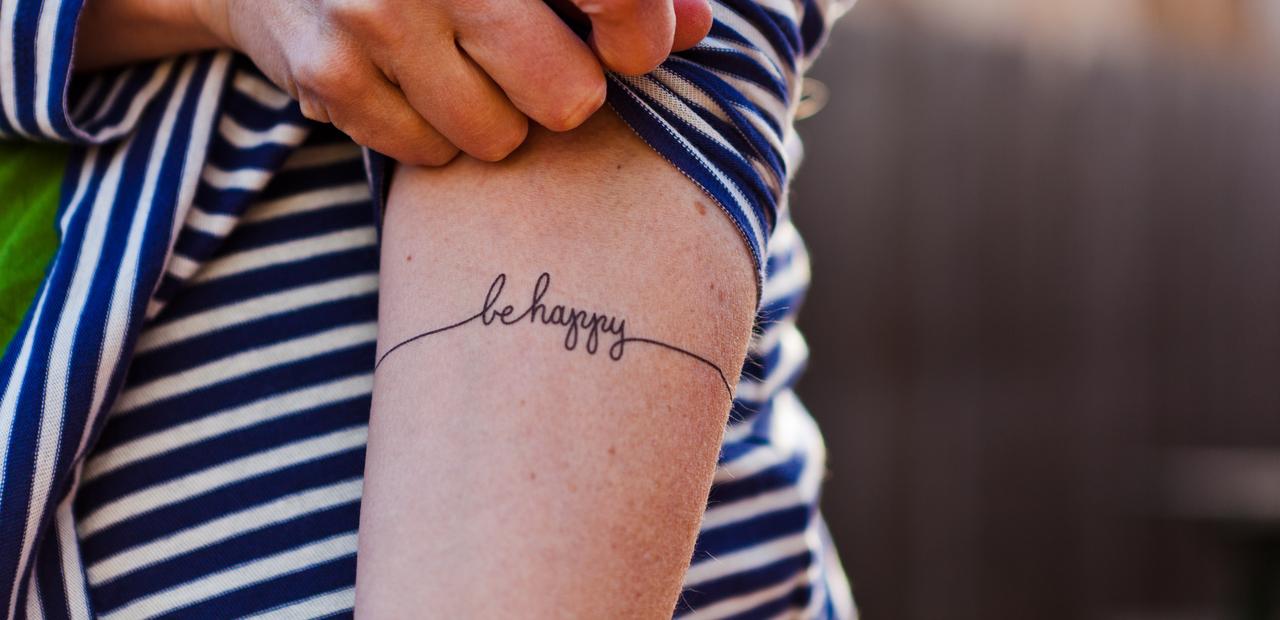 be happy arm tattoo