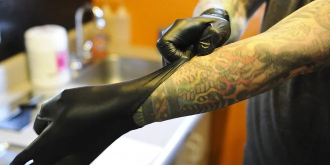 tattoo artist hand with gloves