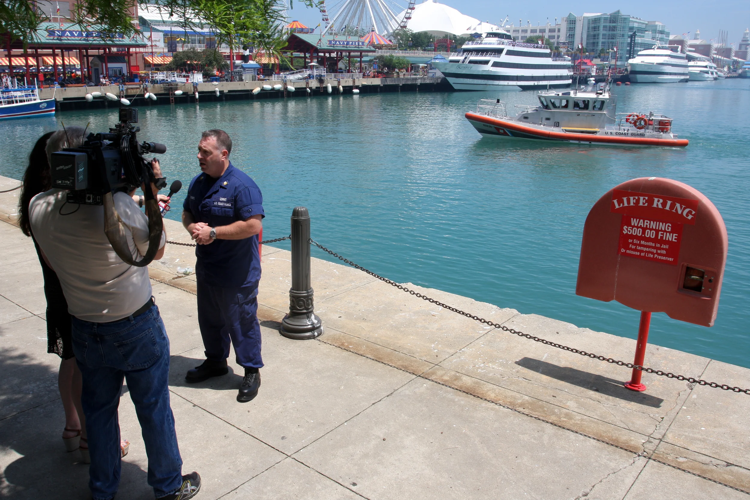 A reporter interviews Petty Officer 1st Class James Strempel about Operation Dry Water at Navy Pier, June 27, 2013. Operation Dry Water is a national boating under the influence awareness and enforcement campaign that lasted June 28-30, 2013. U.S. Coast Guard photo by auxiliarist Jonathan Roth.