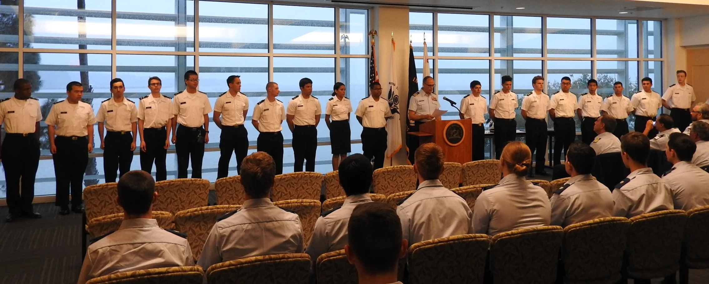 Commander (Ret.) Michael Kazek administering the auxiliary oath before pinning the new AUP seniors. (From right to left: Gary Barker, Dorian Bohorquez, Noah Carter, Oliver Chen, Ezrah Dang, Travis Foster, Amelia Herrman, Charles McDonald, Commander (Ret.) Michael Kazek, Sam Phakhdi, Yaricsa Picon-Carrillo, Kenn Reamico, Sean Resavy, Kolby Saucedo, Briston Siow, Jack Tomasi, Michael Vega, Mijia Wen, Issac Wilkins)