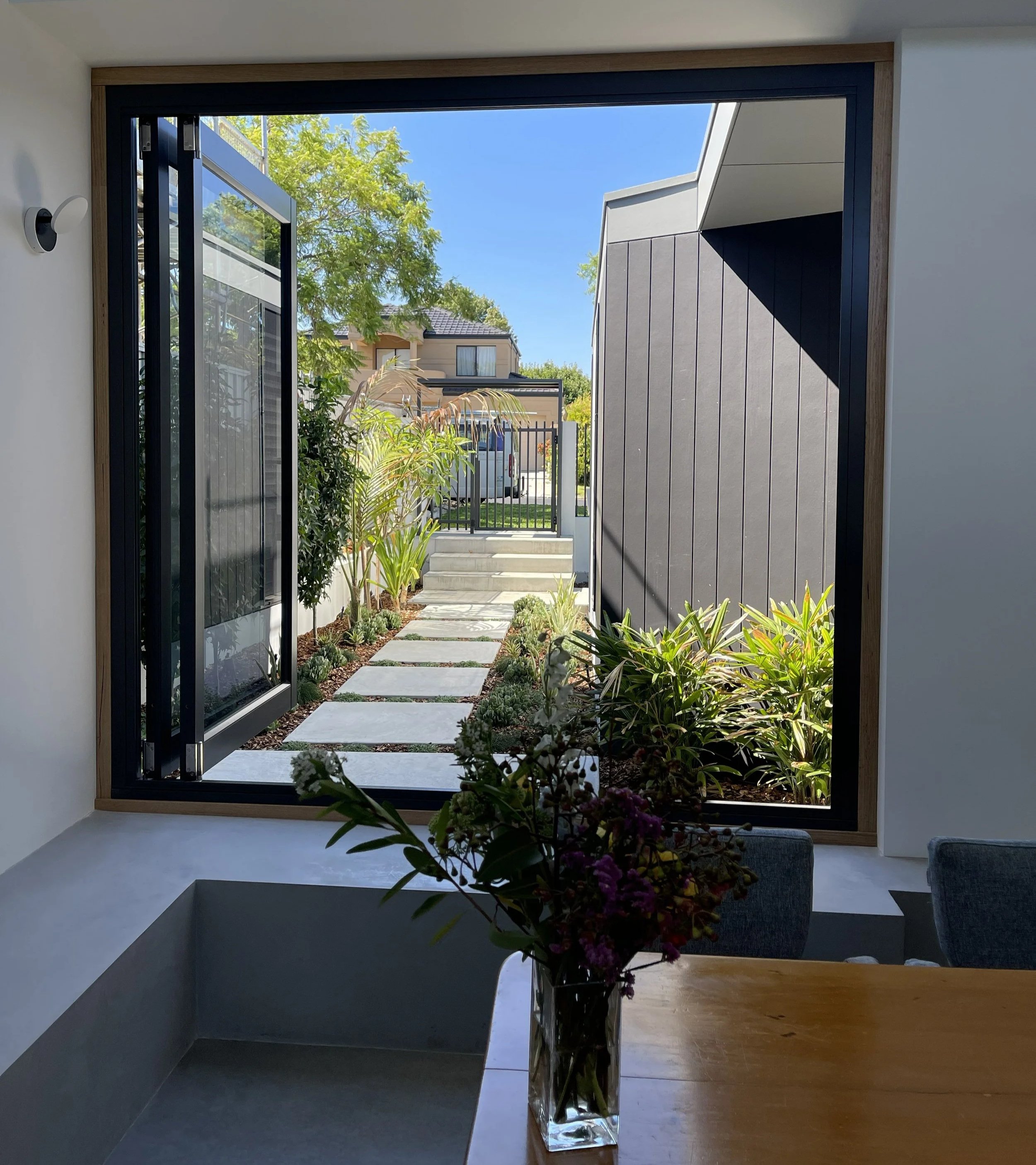 Bifold windows with a daybed for indoor/outdoor living at one of Arklen's new home builds
