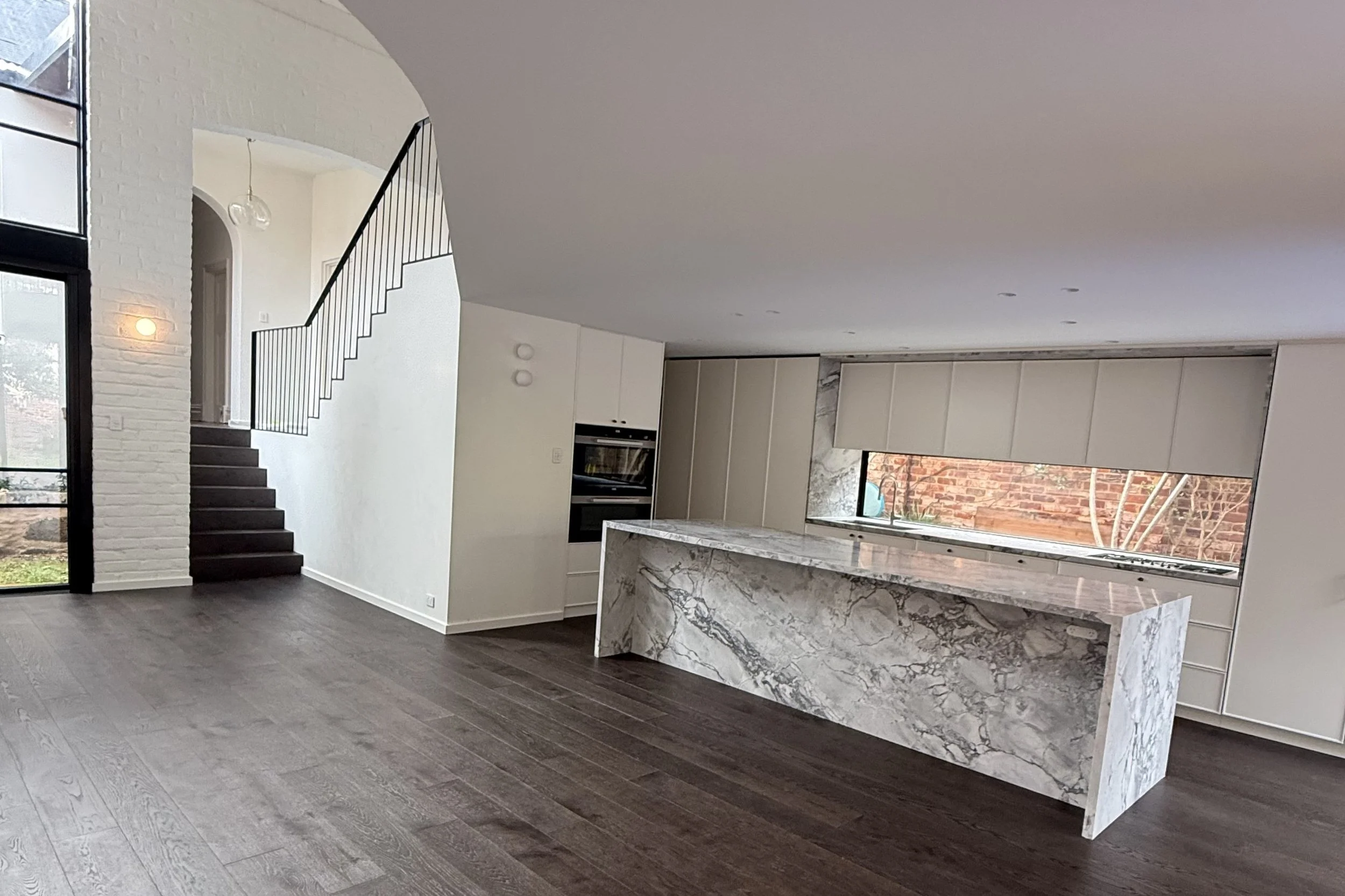 A landscape of a contemporary open-plan kitchen at a renovation in Mosman Park, Perth