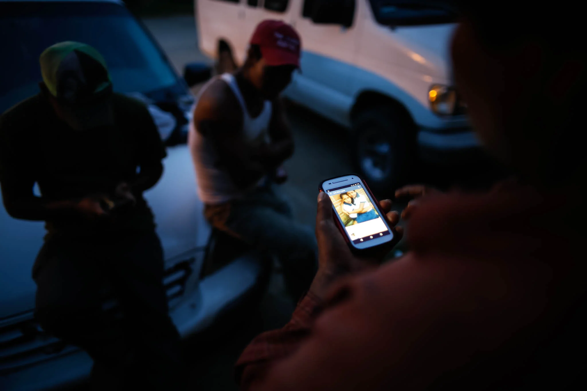 Benjamin Cruz Perez, 42, views a photo of his family in Mexico in front of the apartment he shares with fellow migrant workers.