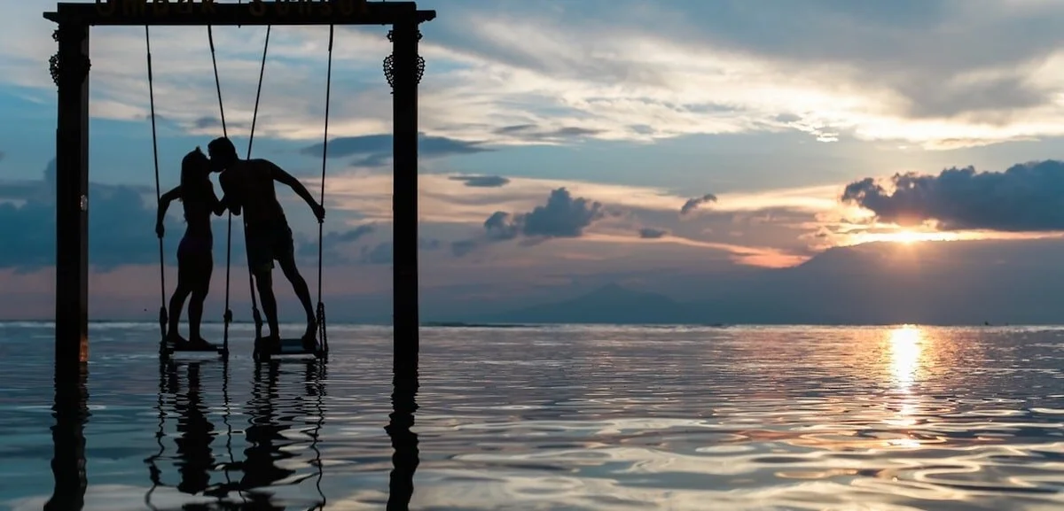 CASEMENT-sunset-waves-couple-kissing-on-swing-min.jpg