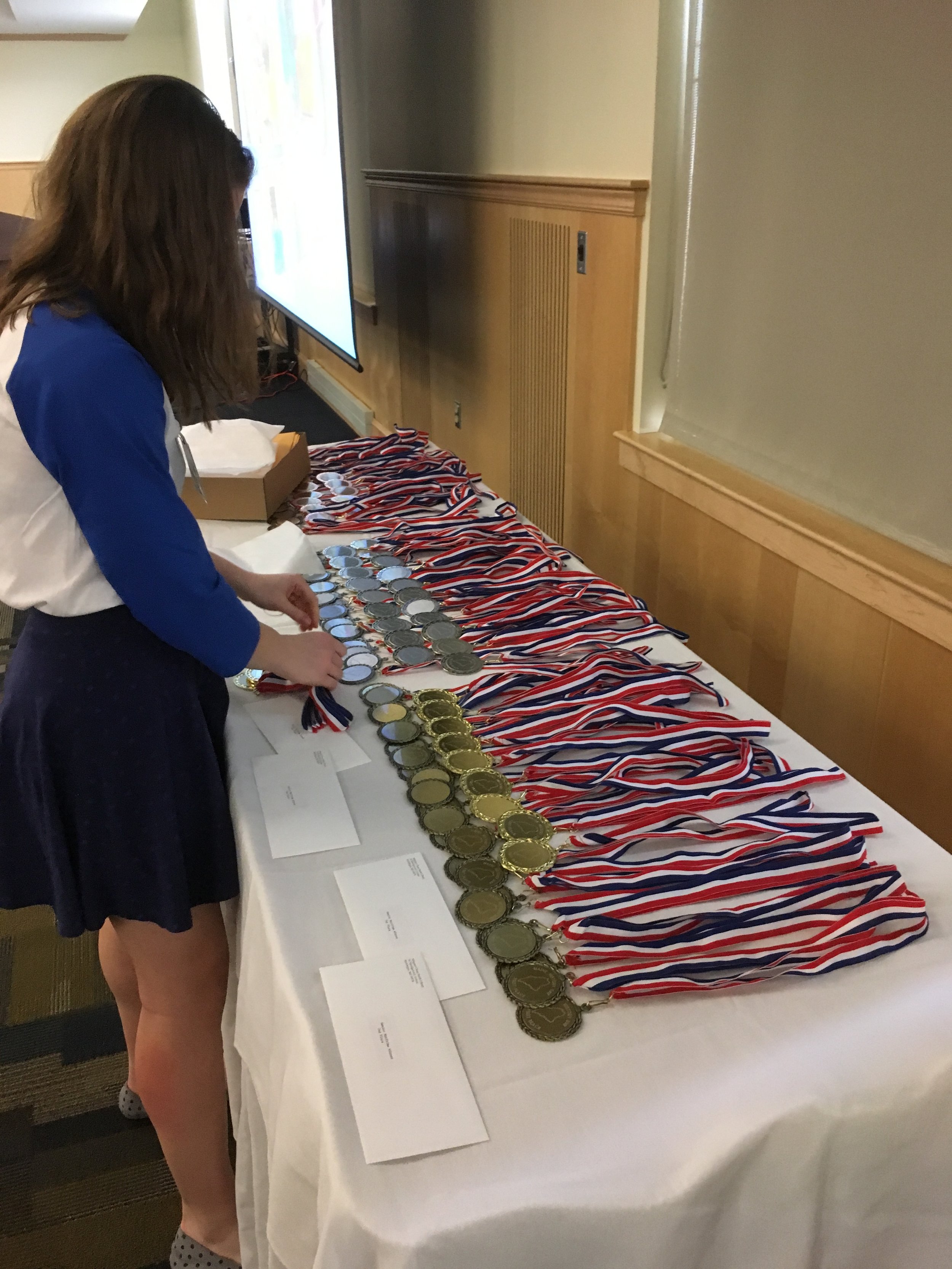 Assistant Coordinator Avery Arena Arranging Medals.jpg