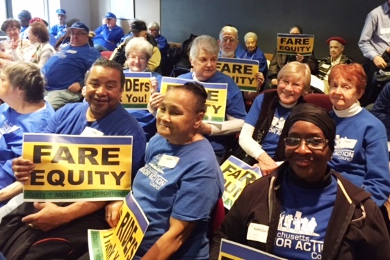 Group of MSAC members sitting with Fare Equity signs