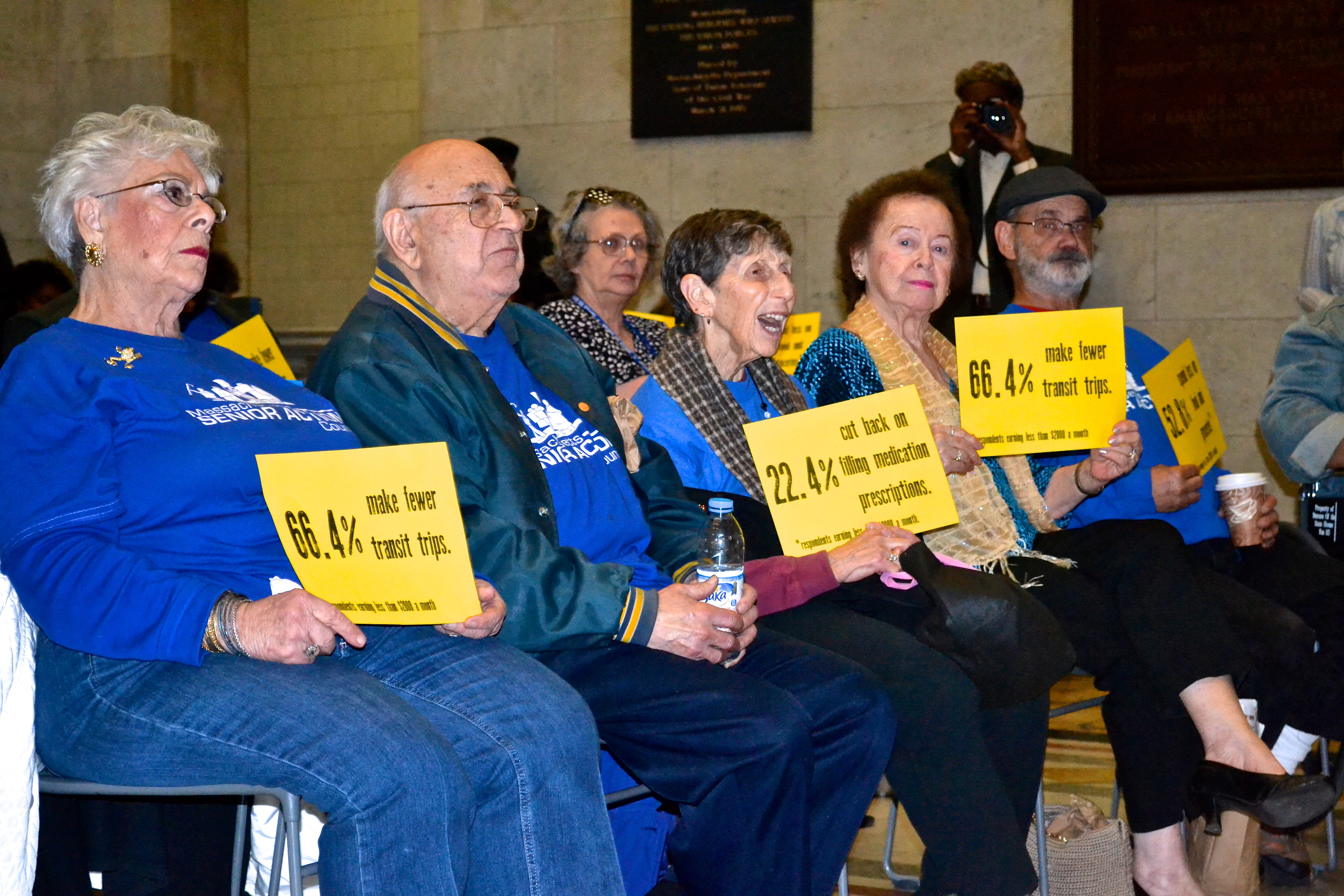 group of seniors sitting holding signs