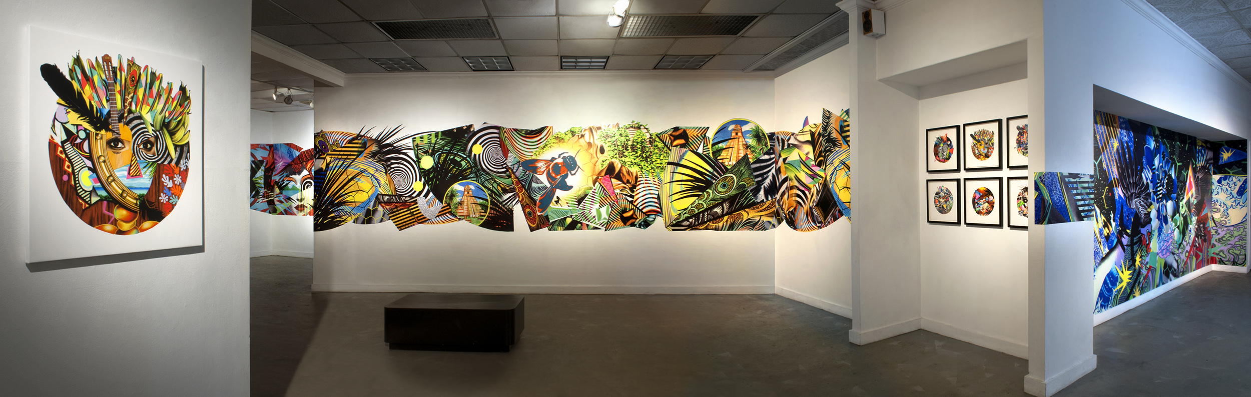 Tropicália: Partial panoramic view of central gallery space with Carnivale Kriol Mask Remix , Jungle Wall Mural vignette, Mask Series works on paper, & Cosmos Wall Mural vignette