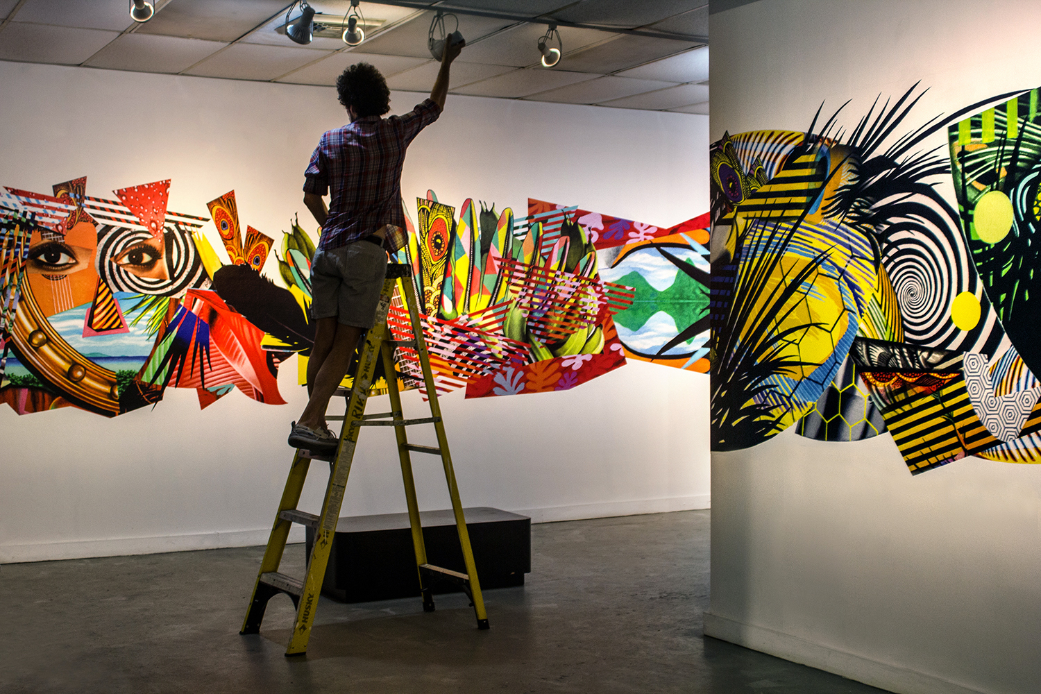 Tropicália Installation Process: Peter D. Gerakaris makes final adjustments after having installed the mural vignettes. Photo credit: Olya Turcihin