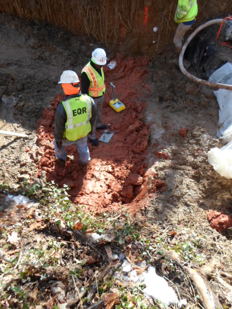 A DDOT inspector tests the density of the compacted clay in the channel block.