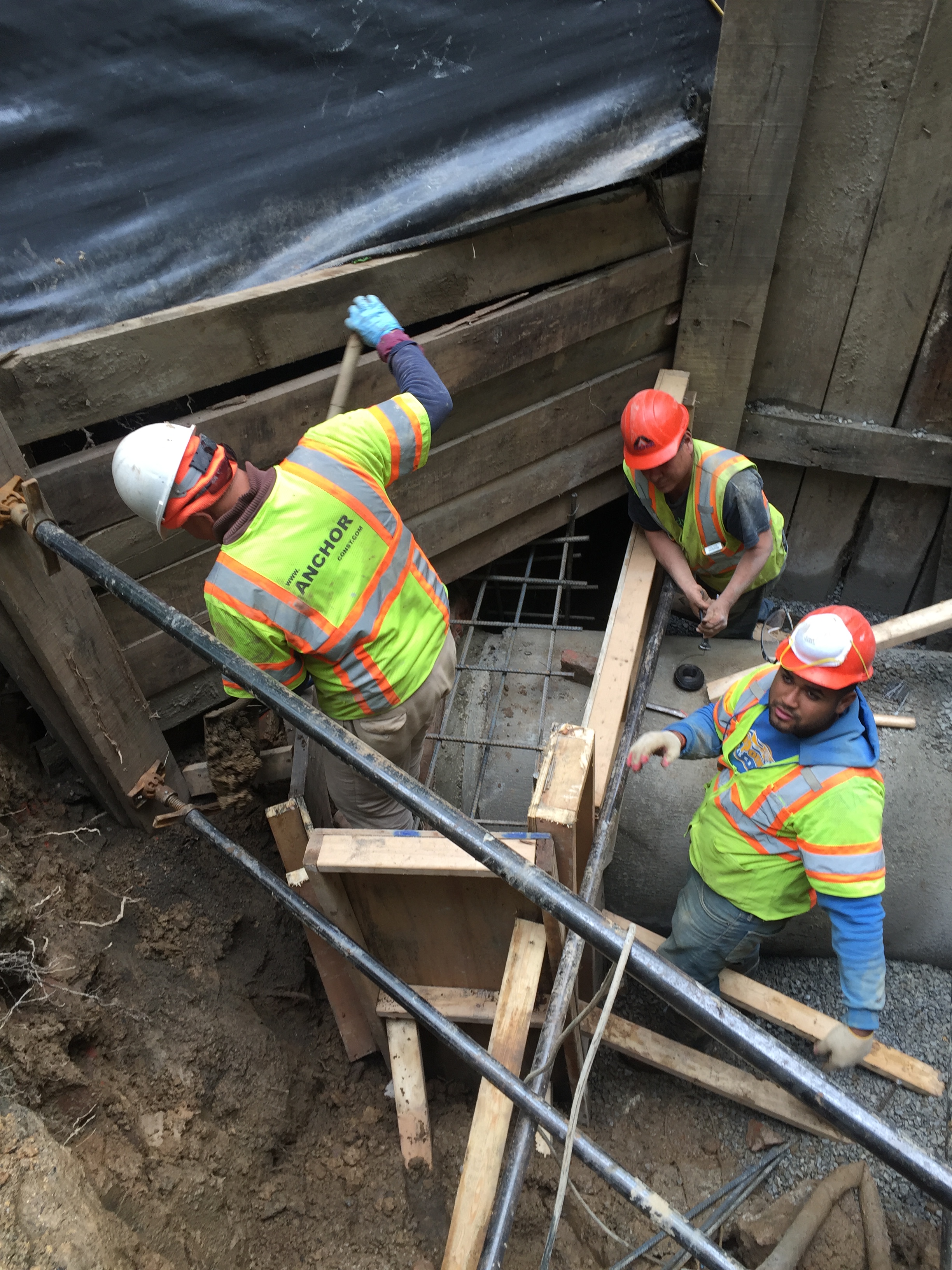 The crew constructs the concrete collar to be placed around the seam between the new and old culvert. Formwork and rebar are installed.