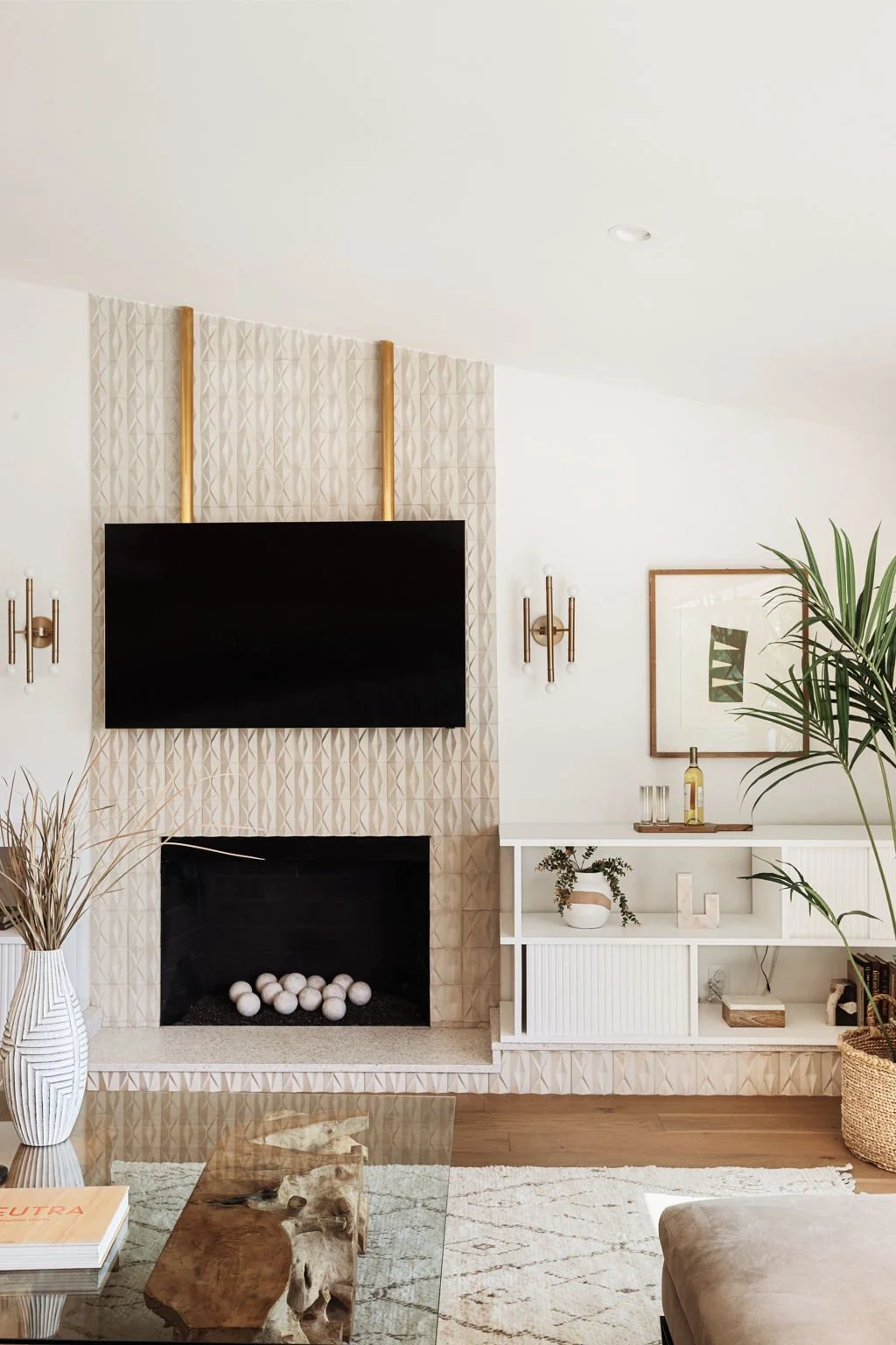  A vignette of a contemporary stone fireplace with decorated built in shelves to the right. 