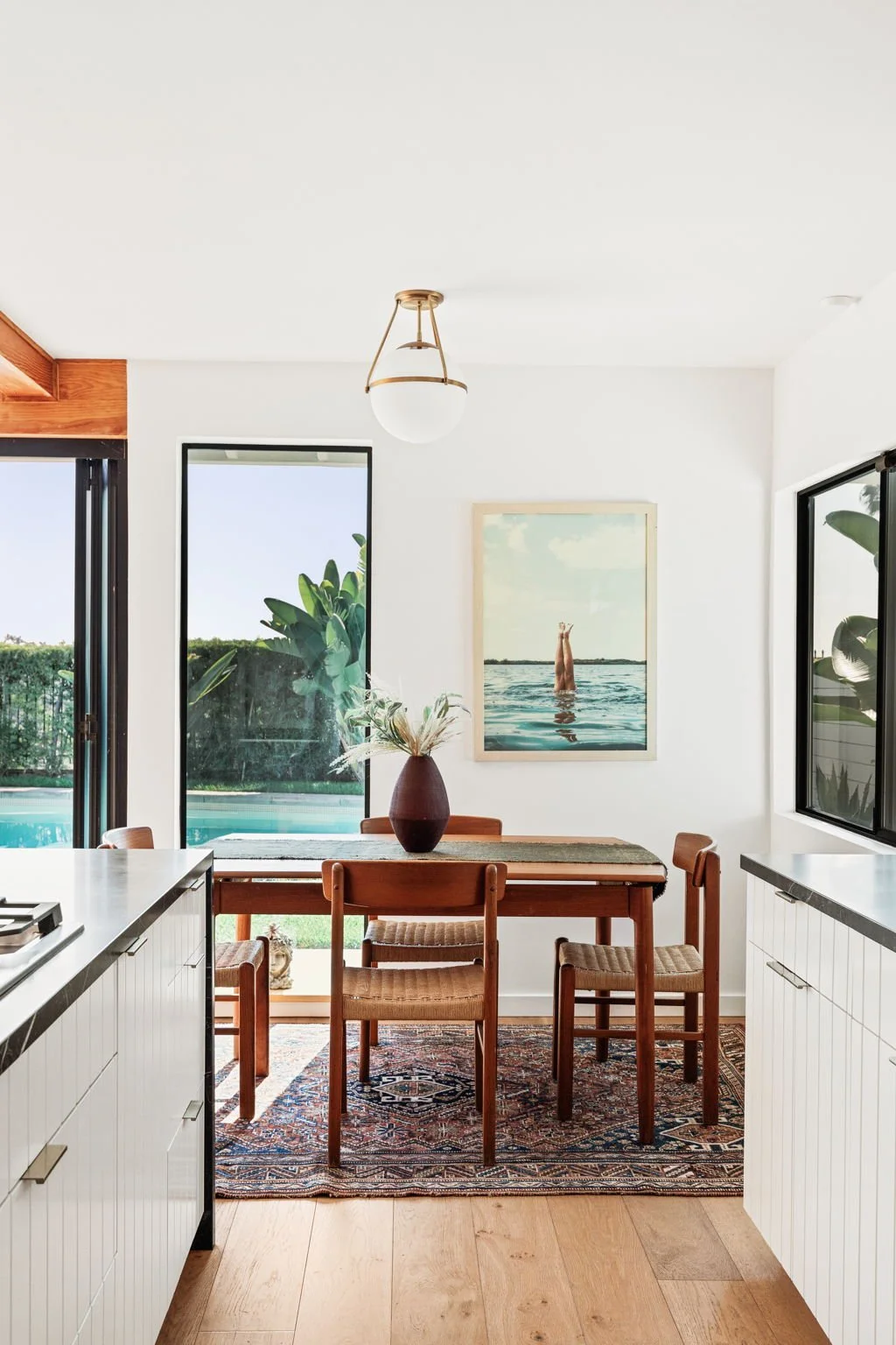  Wooden table with matching chairs, on a patterned rug. 