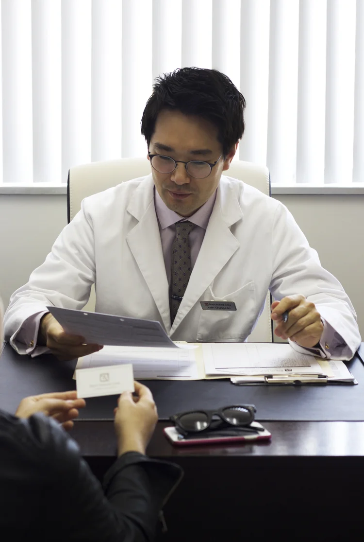 Justin Chung L.Ac. reviewing patient chart at Raah Acupuncture Koreatown Los Angeles