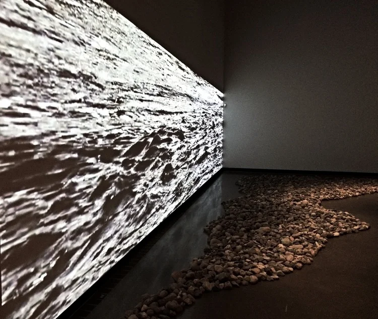 Installation View 38' video, 6 tons of river rock