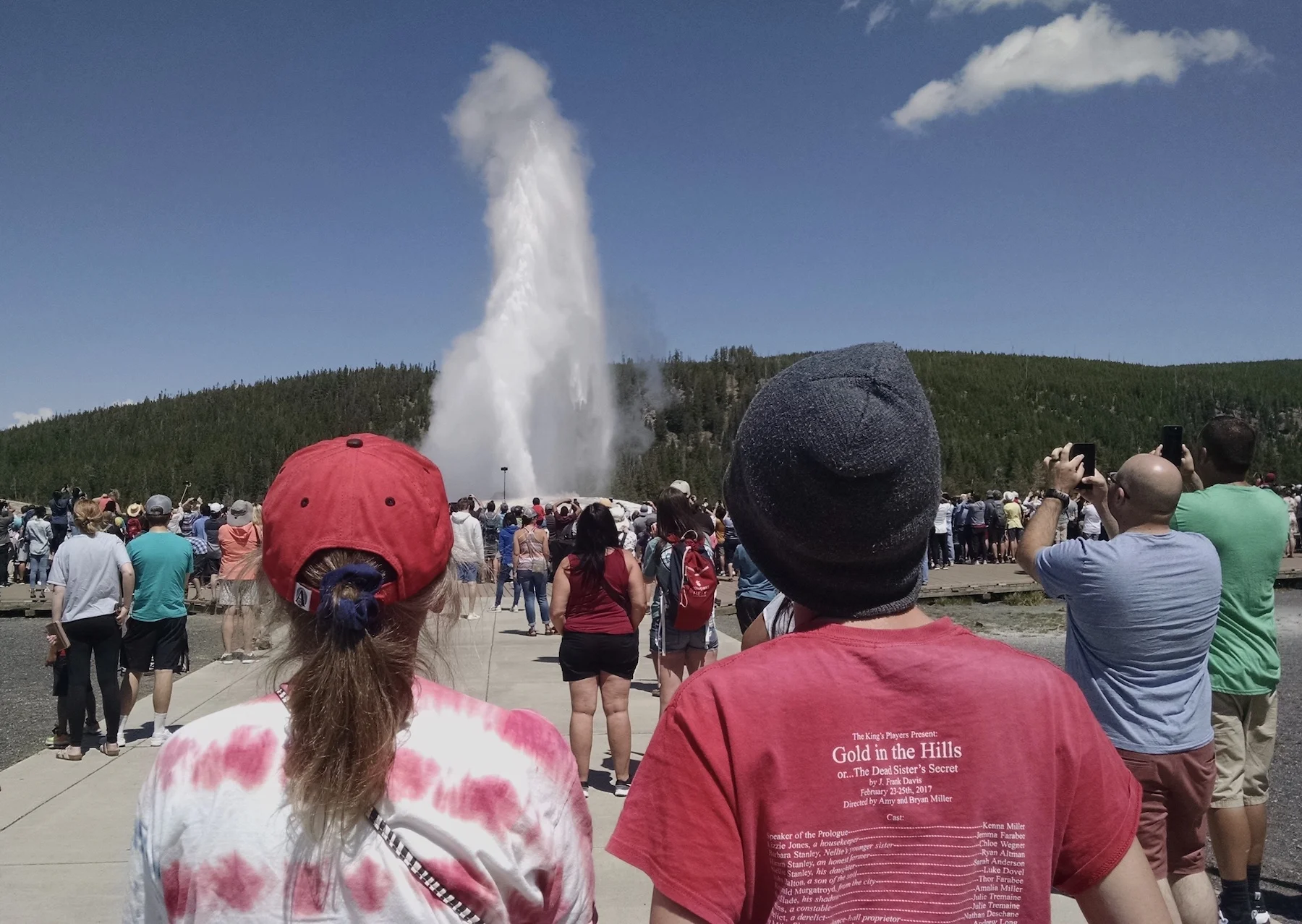 My wife and son watching Old Faithful. We saw it “go off” three times. Once from the observation area, once from the mountain top in the background of this picture, and once through the eruption of Castle Guyser.
