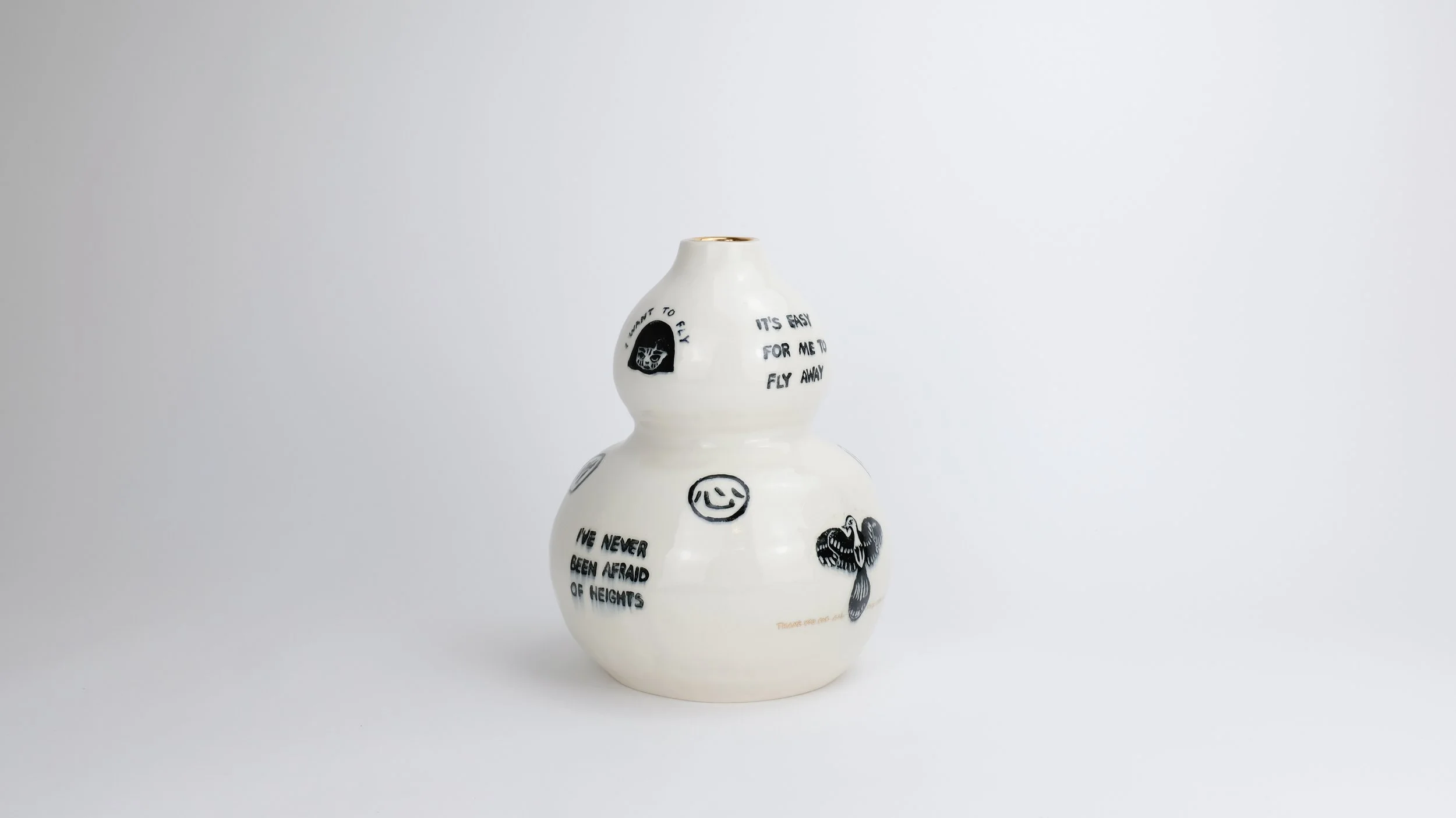 Afraid to Fly, 2025, Block print underglaze on porcelain with gold kintsugi and gold kintsugi words, 8” x 8” x 10”