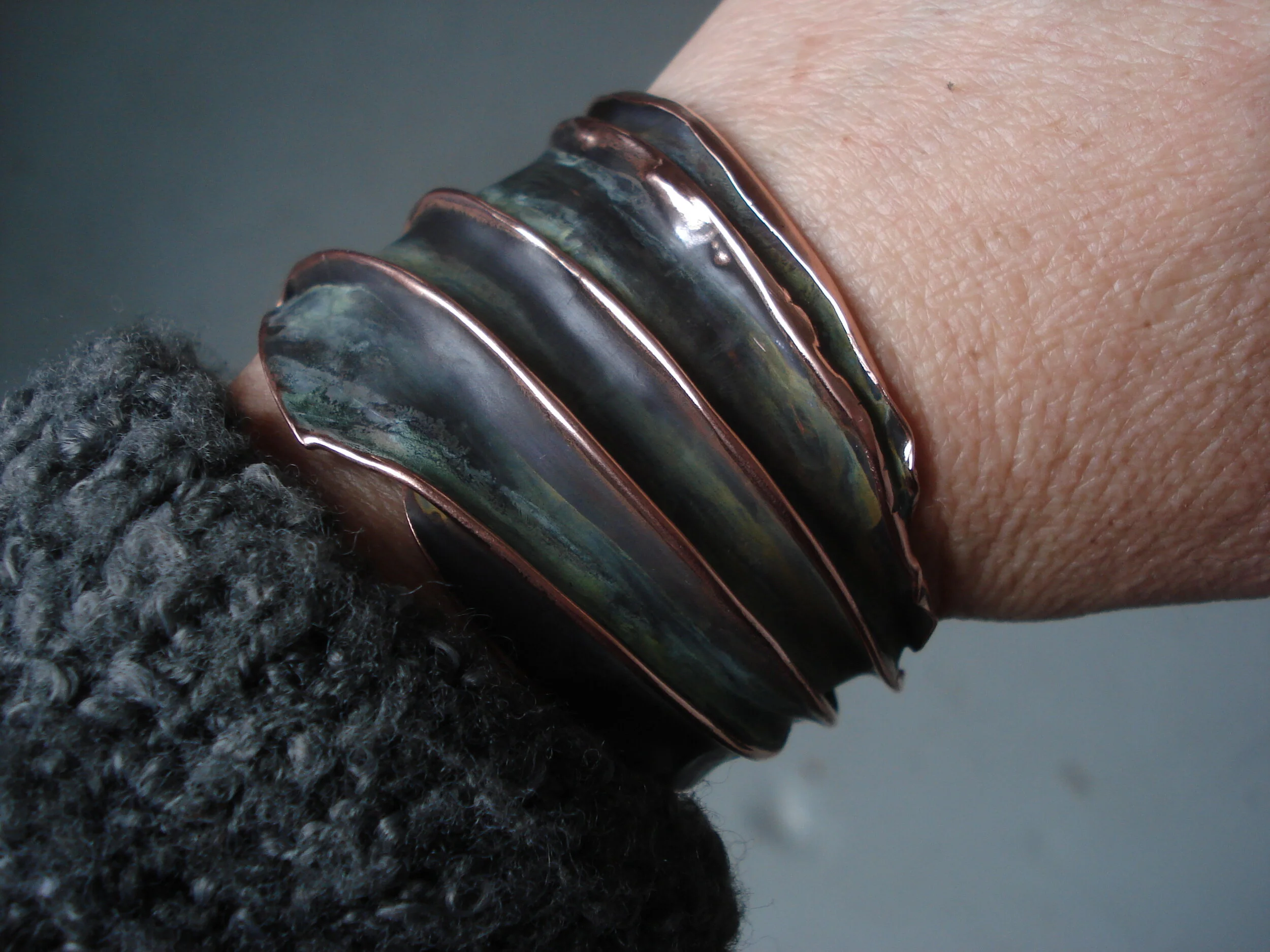 Midnight Sun with green hues on polished copper, cuff bracelet. 