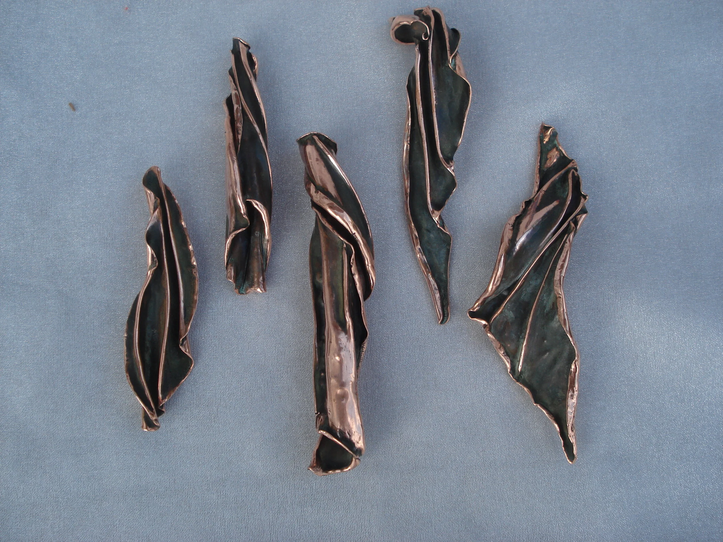 Midnight Sun patina on polished copper. Pendants and passion spinner.