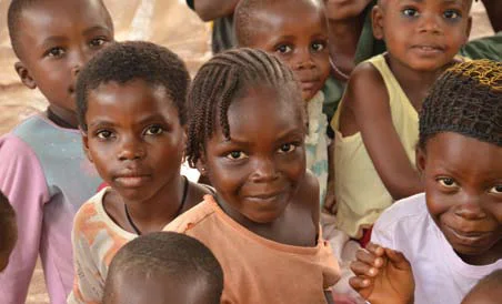 Nigerian children, many orphaned by violence in Nigeria, receive food at a preschool through CRS & Partners. Photo: Michael Stulman/CRS