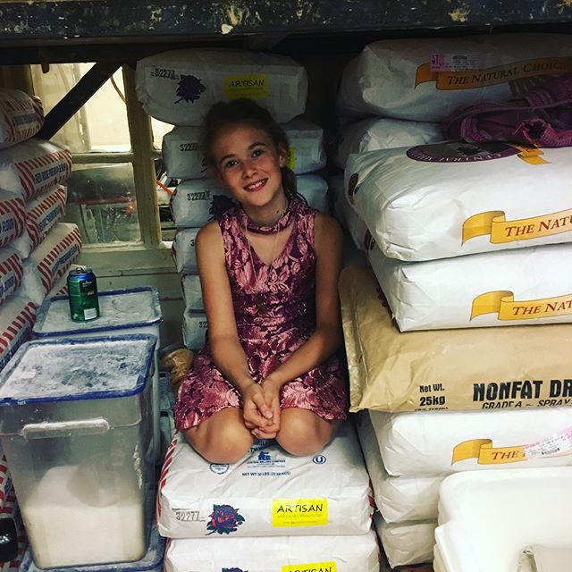 It's a flour-dusted life. A cozy perch at Daddy's bakery is a-ok, and just another Saturday, for these kids.