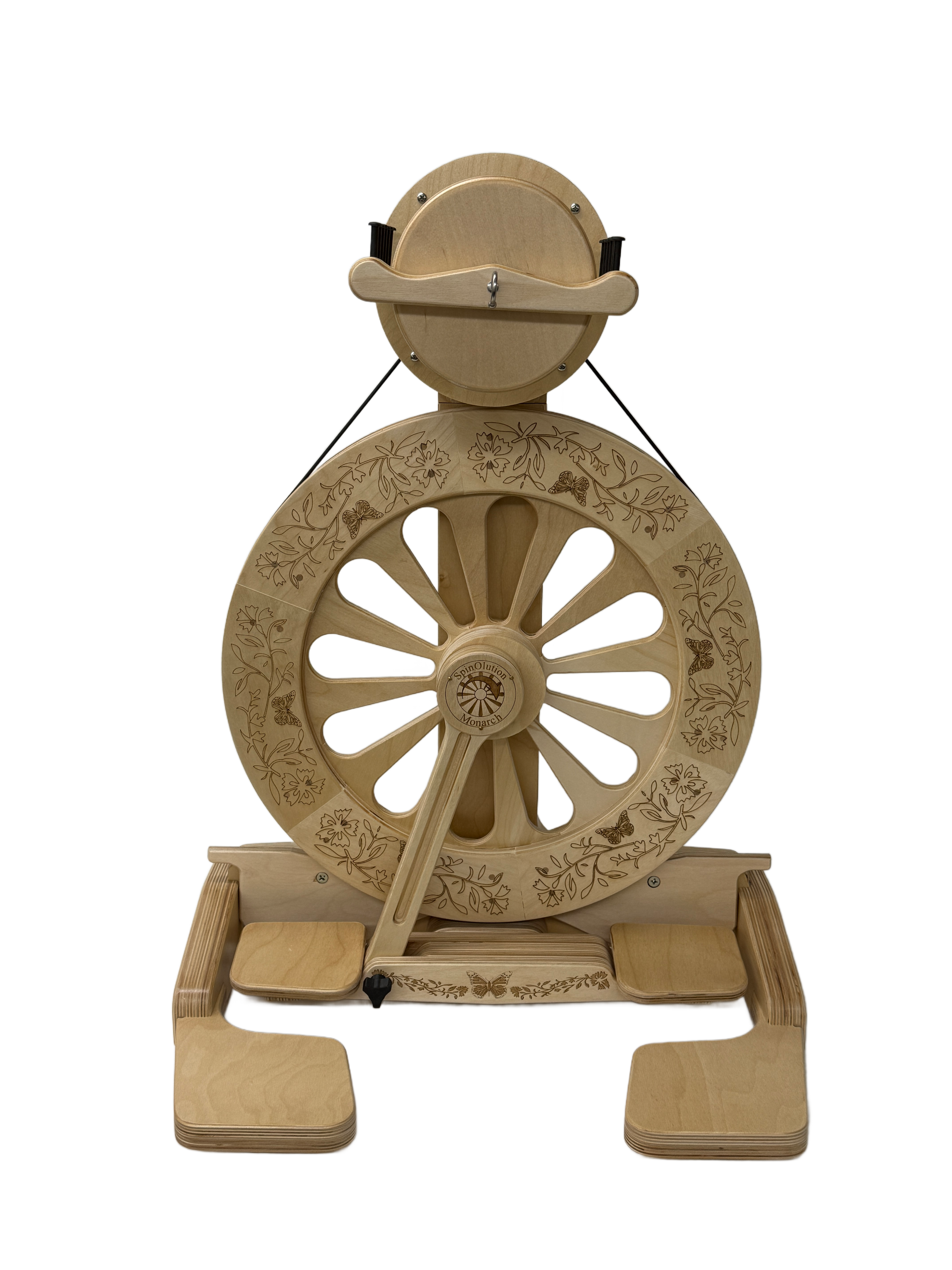Wooden spinning wheel with engraved floral and butterfly designs, featuring a large wheel, a smaller wheel, and a padded base.
