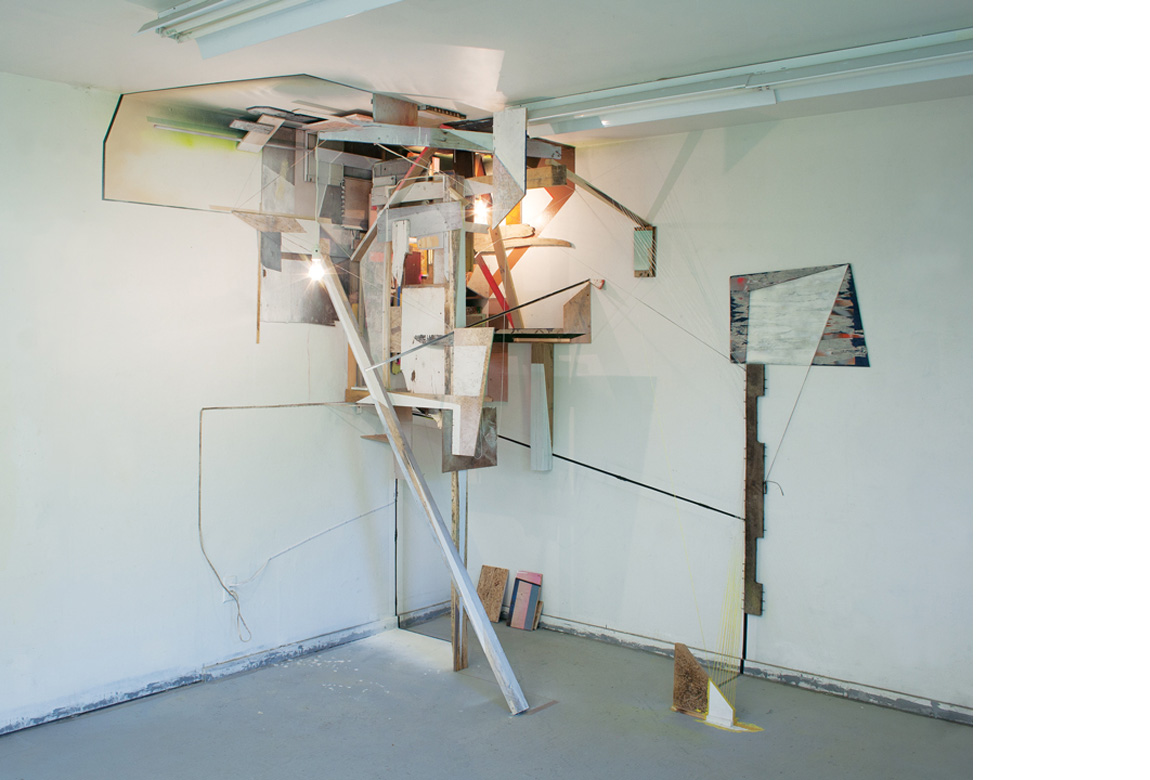 CORNERPIECE, JULY 2011 site specific installation with wood, string, acrylic paint, spray enamel, wire mesh, compact fluorescent light bulb, incandescent light bulb, extension cords, and salvaged building materials, 106 x 183 x 68 inches, 2011