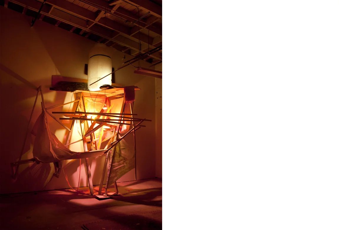 UNDER CONSTRUCTION NO. 1 site specific installation with wood, cellophane, aluminum, acrylic paint, spray enamel, cardboard, light bulbs, fan, extension cords, clear polyethylene sheeting, vinyl siding, flagging tape, and bubble wrap, 178 x 196 x 62 inches, 2013