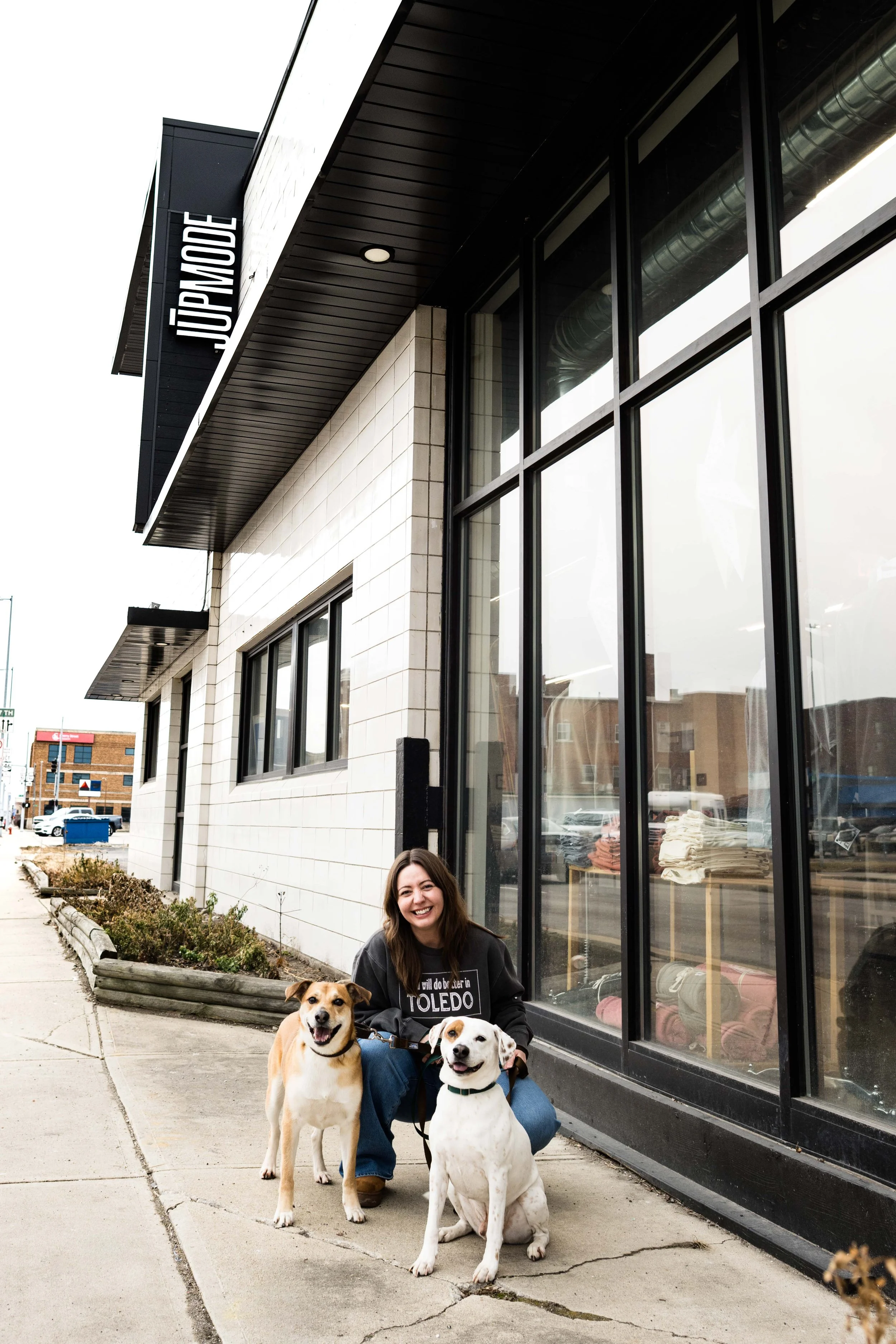 employee with dogs in front of jupmode sign