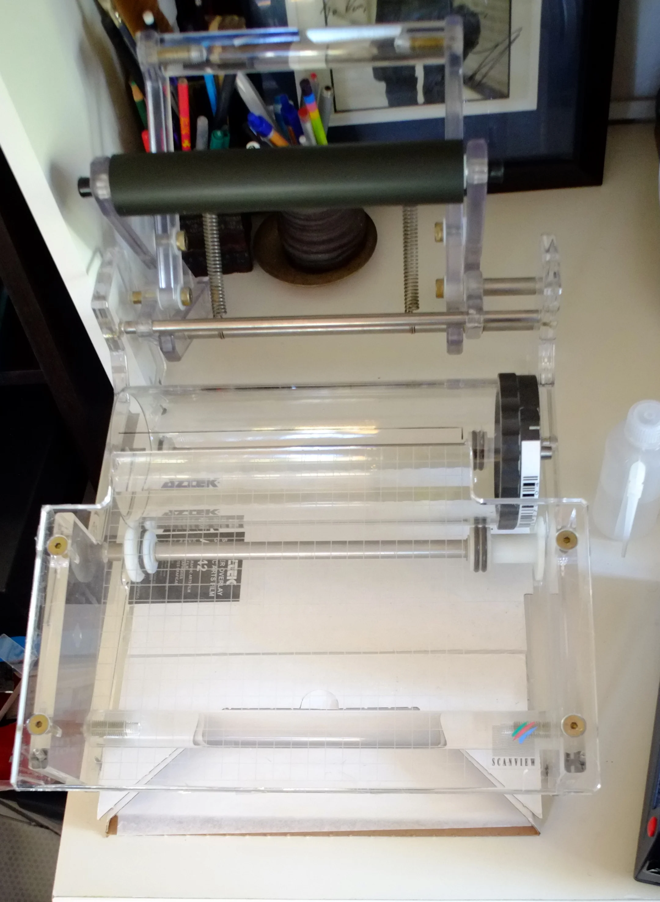 A wet mounting station holds the drum in place, while the roller on top helps to press the mylar sheet onto the film, getting rid of most of the bubbles.