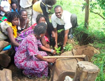 Geofrey, in white, helps the graduating clients to plant a celebratory tree