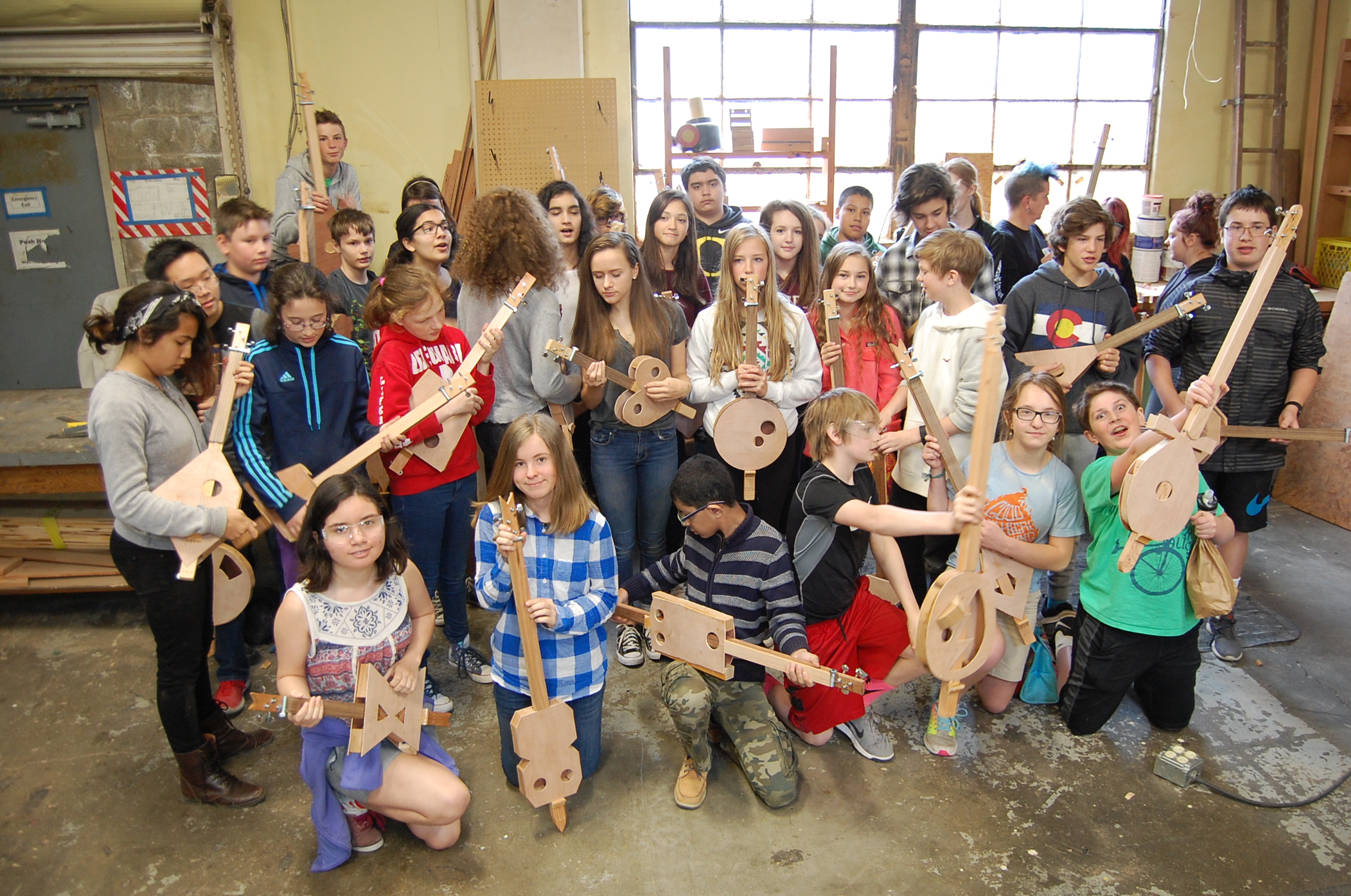 7th grade class posing with their new 3-string instruments