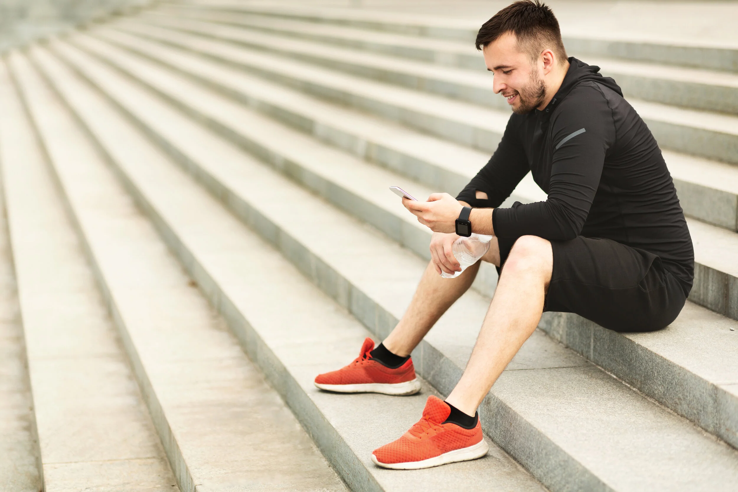 man-texting-on-cellphone-while-sitting-on-stairs-a-TBAJYWG.jpg