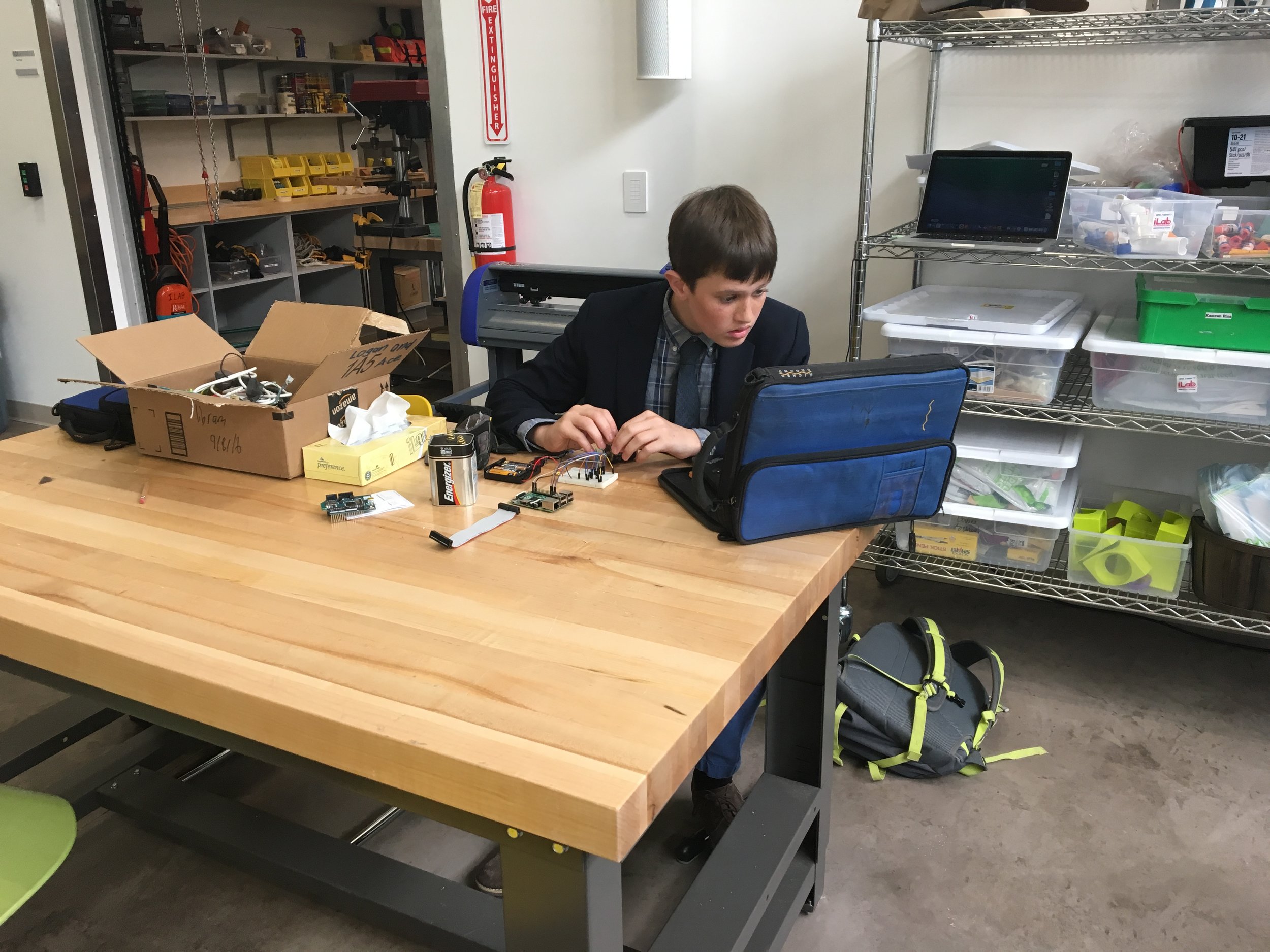 A student works in the Innovation Center to wire and solder the servo motor