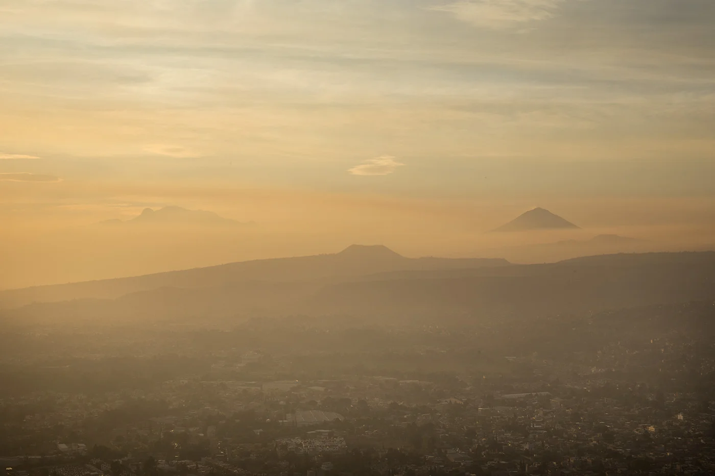 Iztaccihuatl, Popocatepetl and Teuhtli volcanos from the top of the Xochitepec during sunrise. 