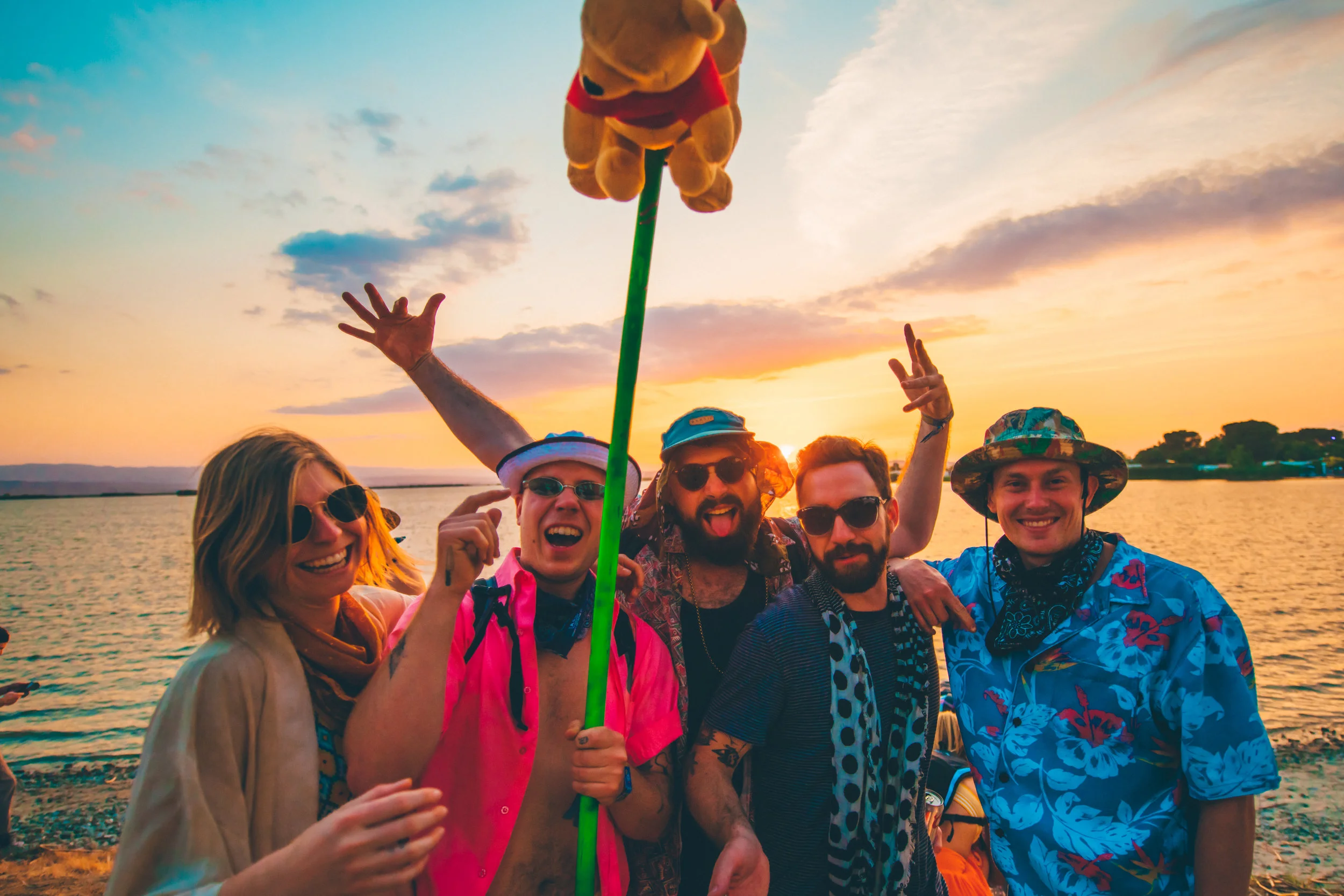 A group of smiling attendees poses for a selfie during sunset. 📷: Juliana Bernstein