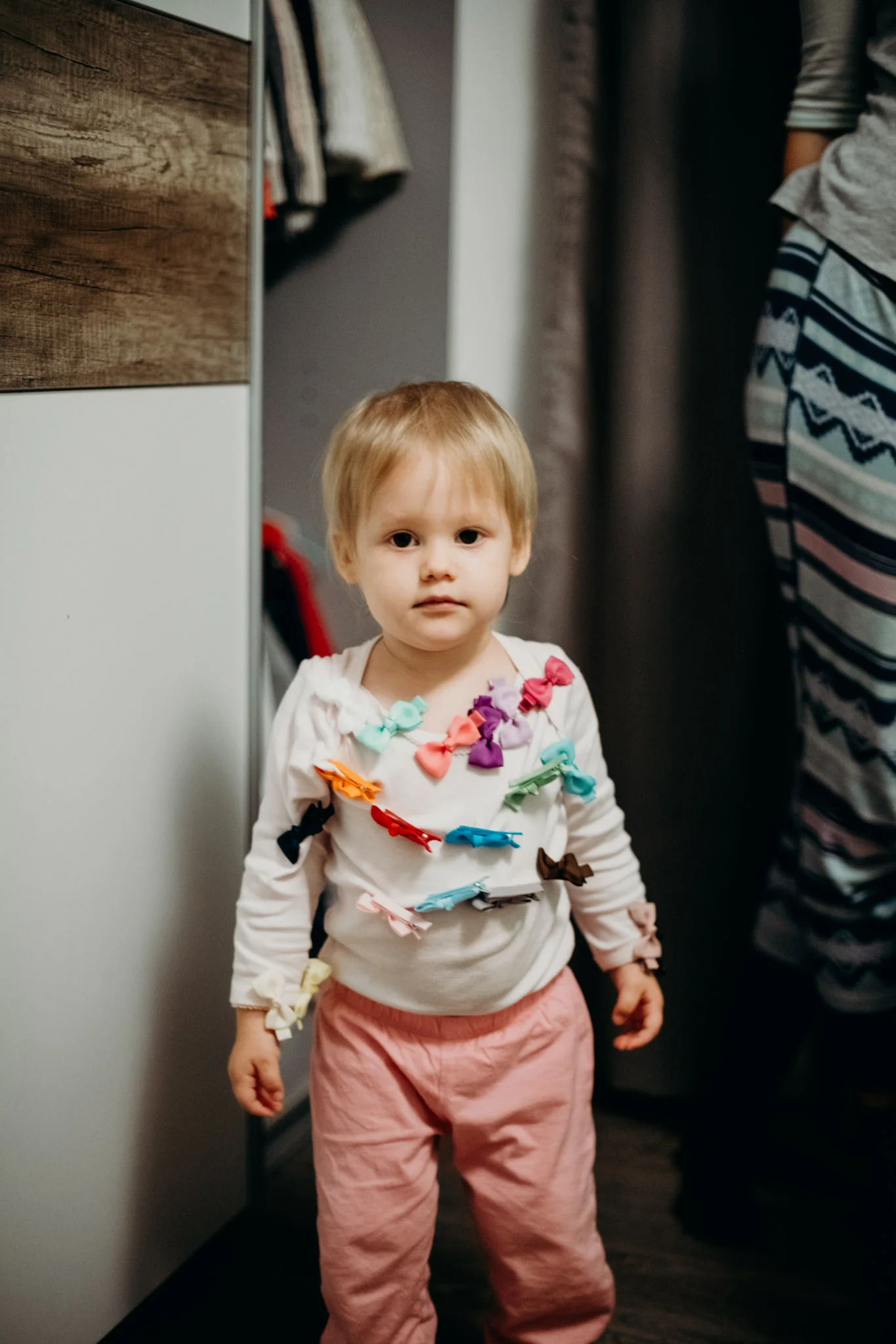 Leya finds her bows. Dad clips them all over her shirt.
