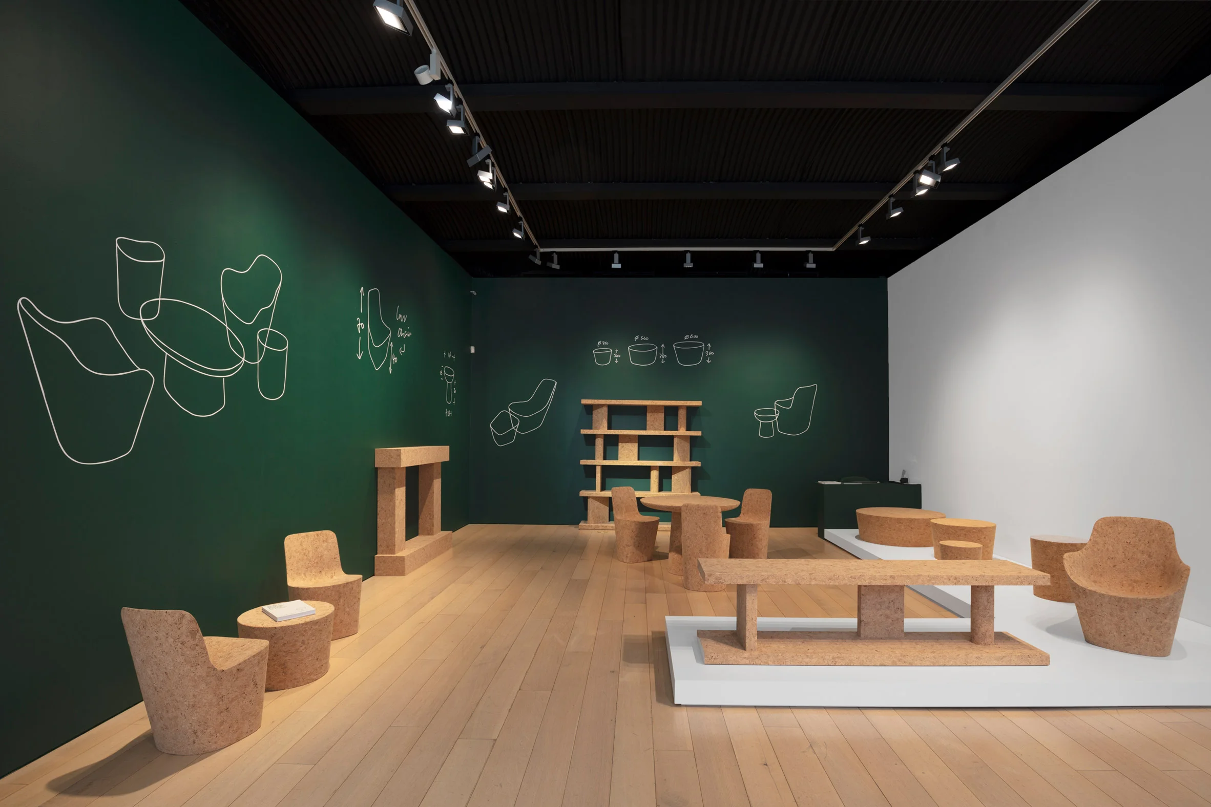 One area of the exhibition has a dark green backdrop. Photo is by Diego Flores