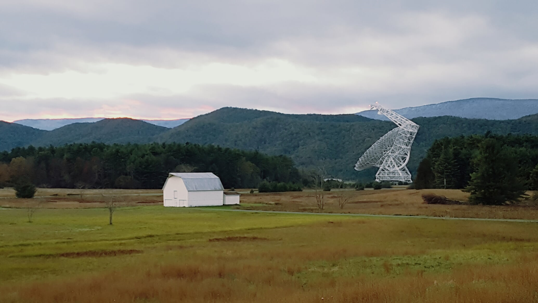 The GBT lies across a field from the main observatory buildings, including the Jansky Lab, the residence hall, and the science center.