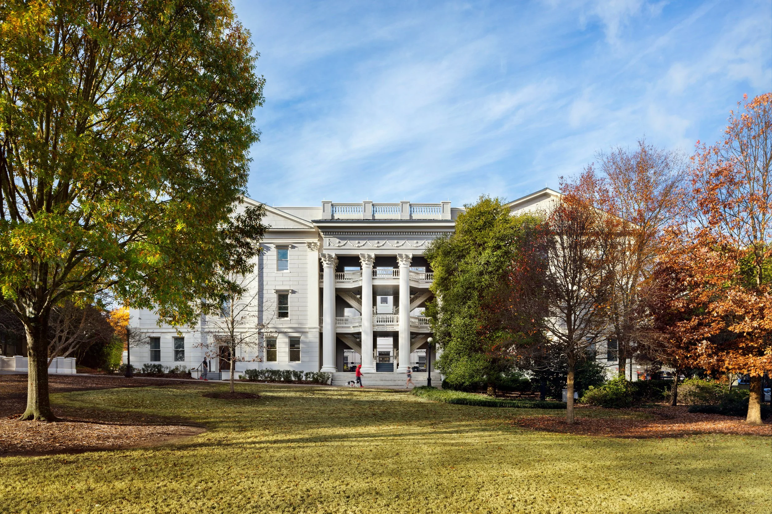 Historic building with white columns and trees in a park setting