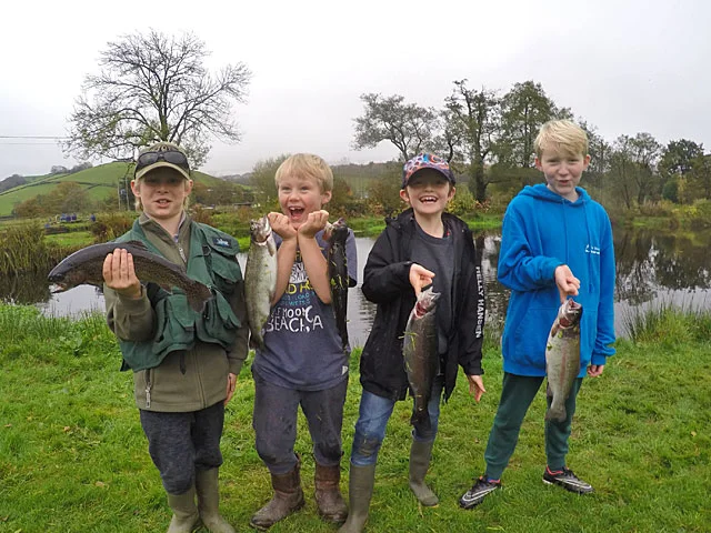 Four very happy boys enjoy there school holiday with a visit to Lobbs Lake at Exe Valley Fishery