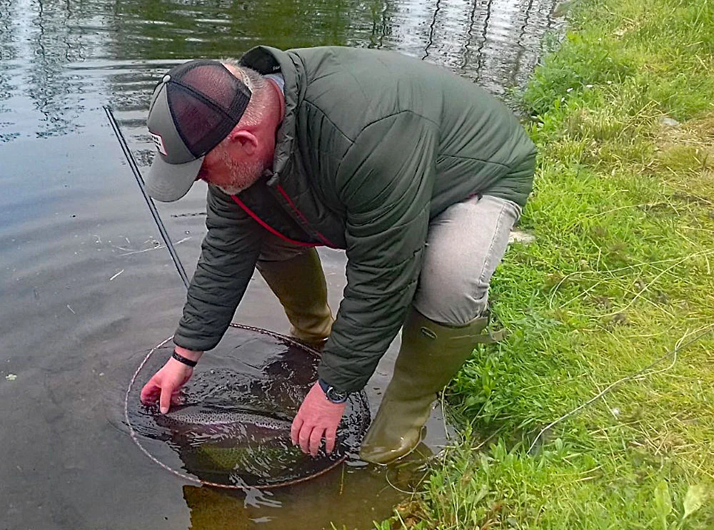 Exe Valley Fishery regular, John Akhurst, successfully releasing a stunning Anchor Lake Rainbow Trout