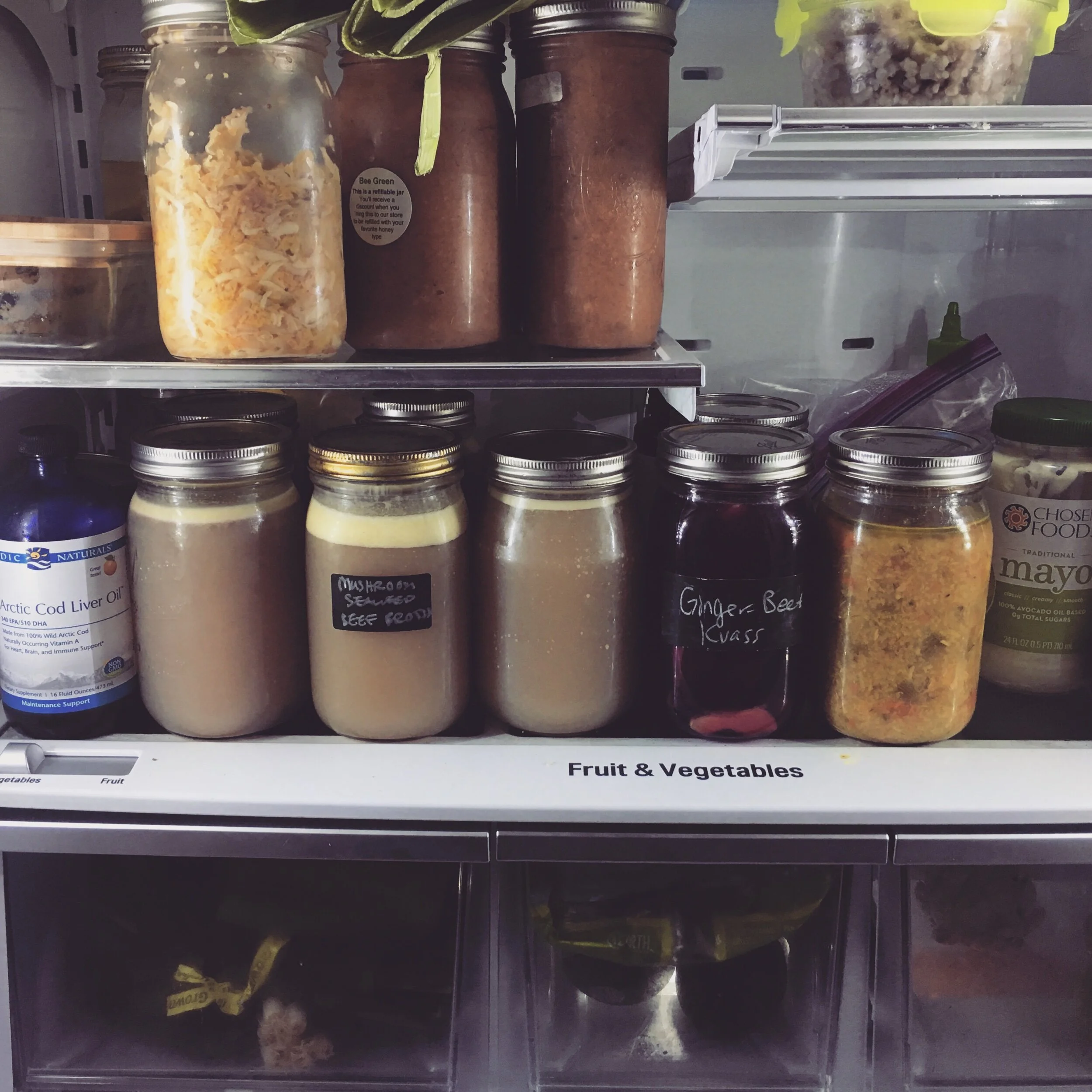 A current snapshot of my fridge, Contents in case you’re interested (from top left): baked sweet potato, apple parsnip kraut, apple-quince sauce, leftover buckwheat, cod liver oil, bone marrow and oxtail pho broth, mushroom seaweed beef broth (from second batch), ginger beet kvass, leftover chicken soup, avocado oil mayo.