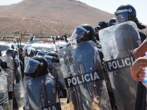 Police stand watch over a road that was previously blocked by fisherman protesting the housing company MIRA.