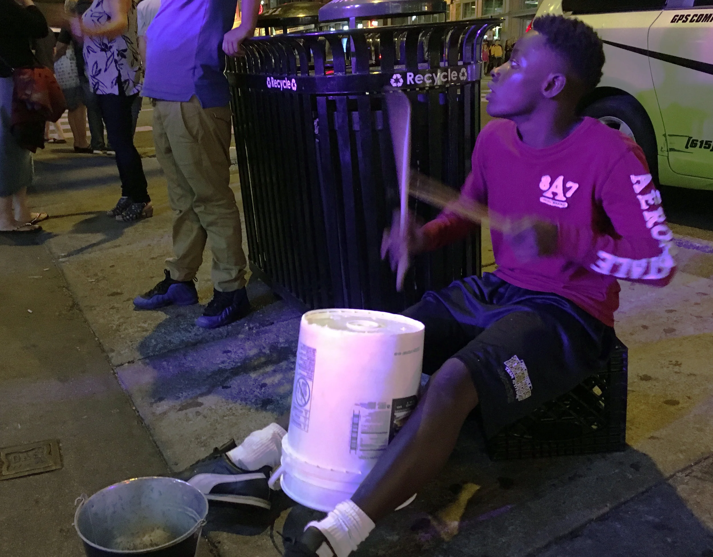 A street busker plays complex beats on an upside down bucket for tips outside the honky-tonks of Lower Broadway in Nashville, TN on Thursday, September 27th, 2017. His talent was evident as passers-by stopped to listen and drop some money in his buc…