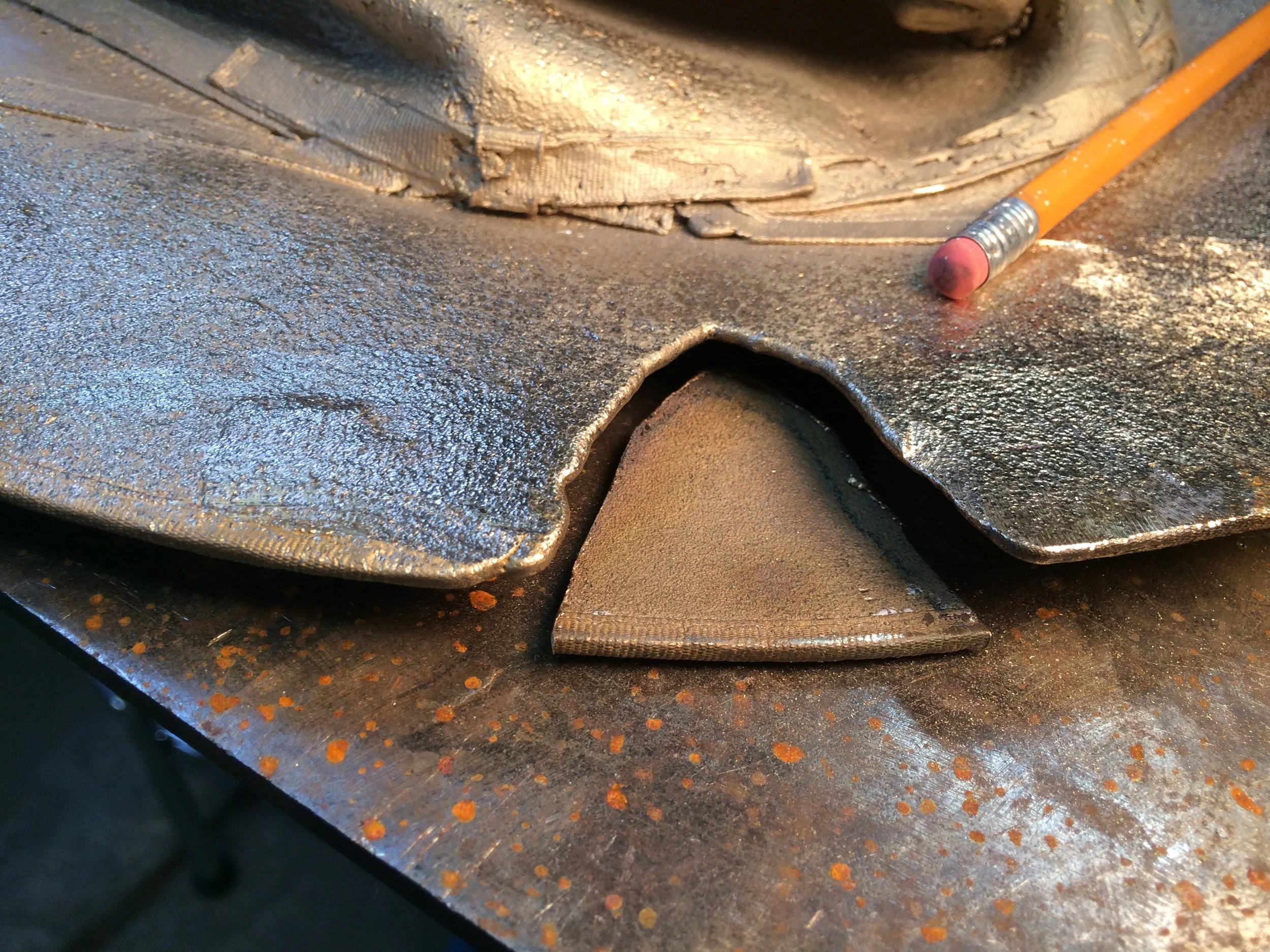 I have decided to make this look like a tear. I cut a piece off another hat and will grind it and weld it to look like it is almost completely torn off. 
